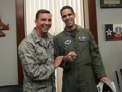 Col. Alan Lake (left), 12th Mission Support Group commander, surprises Lt. Col. Tom Kublie, 19th Air Force Undergraduate Training Branch chief, on Oct. 21 with an all-expense paid trip for two to watch the Arizona Cardinals play the St. Louis Rams on Dec. 7. Colonel Kublie entered the Football Frenzy competition held by the Air Force Services Agency and was selected as the regular season game package winner. The grand prize, which includes an all-expense paid trip for two to Super Bowl XLIII in Tampa Bay, Fla., will be held in early January. Services Club members who attend a Football Frenzy celebration at the enlisted or officers' club can enter by filling out a form, with no purchase neccessary. (U.S. Air Force photo by Rich McFadden)