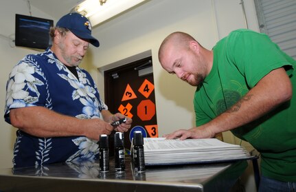 Munitions inspectors Avery Phillips (left) and Jeremy Peterson go over inventory of police issue pepper spray at the new munitions storage facility on Randolph Air Force Base on Oct. 17. (Air Force photo/Melissa Peterson)