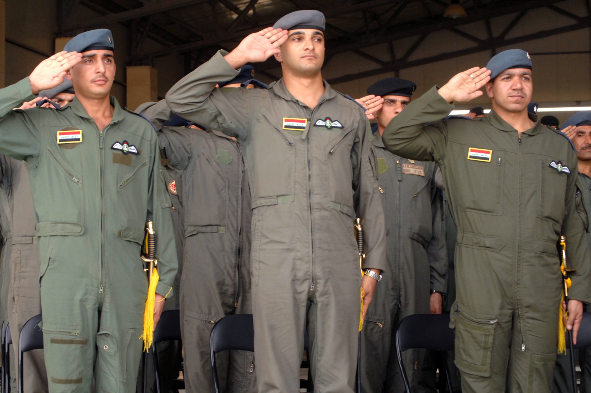 Iraqi air force 2nd Lts. Habeeb, Majid and Hassan salute during the Iraqi national anthem at their graduation ceremony from Iraq's only fixed-wing flight training school Oct. 13 at Kirkuk Regional Air Base, Iraq. One graduate plans to become an instructor pilot for the school, and another will fly a King Air twin-turboprop aircraft on operational missions. The third will travel to the United States to learn to fly the T-6 Texan. (U.S. Air Force photo/Senior Airman Randi Flaugh)