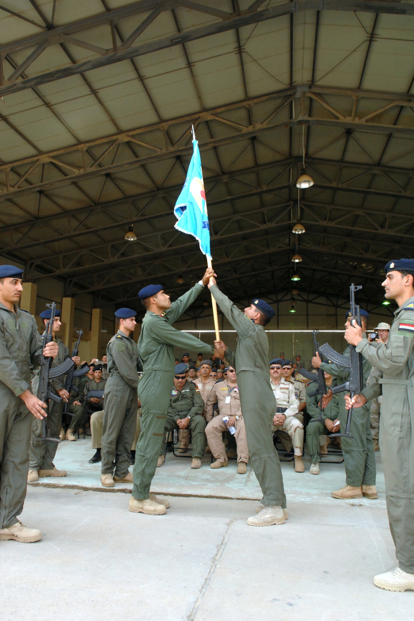 Iraqi airmen pass the class flag to the senior class during a graduation ceremony at Kirkuk Regional Air Base, Iraq, Oct. 13. Three Iraqi airmen received their wings during the ceremony. (U.S. Air Force photo/Senior Airman Randi Flaugh) 
