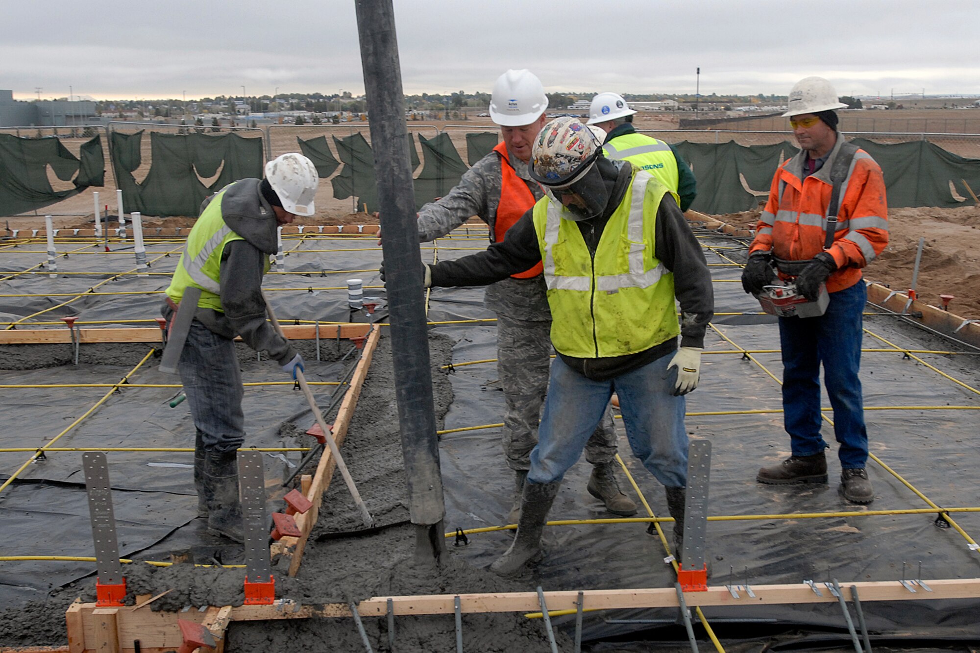 Col. Jay Raymond, 21st Space Wing commander, with Tierra Vista personnel guides the concrete pumper  to begin pouring the foundation of the first new TVC home on Peterson AFB. This marked the beginning of phase one of new construction on the privatized housing development. This initial phase will include 93 homes. (Air Force photo/Larry Hulst)
