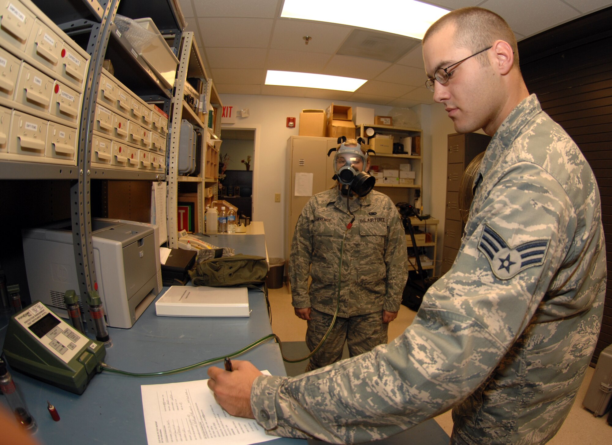 Senior Airman Derek Johnson from the 4th Aeromedial Dental Sqaudron administers a gas mask fit test to Senior Airman Rebecca Laurence from the 4th Logistics Readiness Squadron on October 9, 2008 at Seymour Johnson Air Force, North Carolina. During a fit test airmen will go through an array of different head movements that they will encounter while deployed, to make sure there is a tight seal. (U.S. Air Force photo by Airman 1st Class Gino Reyes)