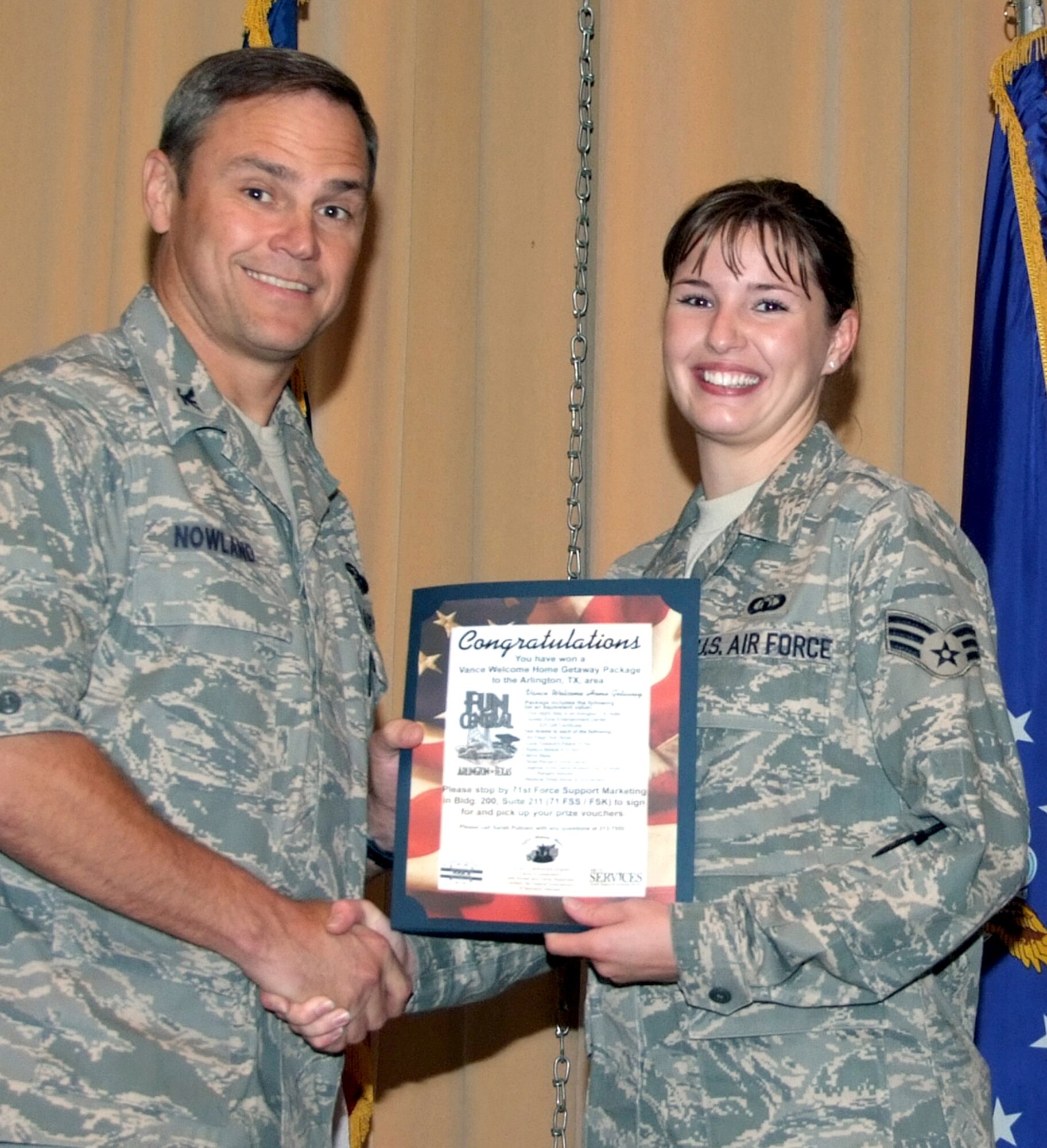 Senior Airman Ashleigh Barber, right, is presented the Vance Welcome Home Getaway Package by Col. Mark C. Nowland, 71st Flying Training Wing commander, during the Wing Recognition ceremony held Sept. 30, in the Base Auditorium, Bldg. 550. Airman Barber, a recent deployer, won a vacation package to the Arlington, Texas, area, as part of a program sponsored by Vance Services and the Airman & Family Readiness Center. (U.S. Air Force photo by Terry Wasson) 