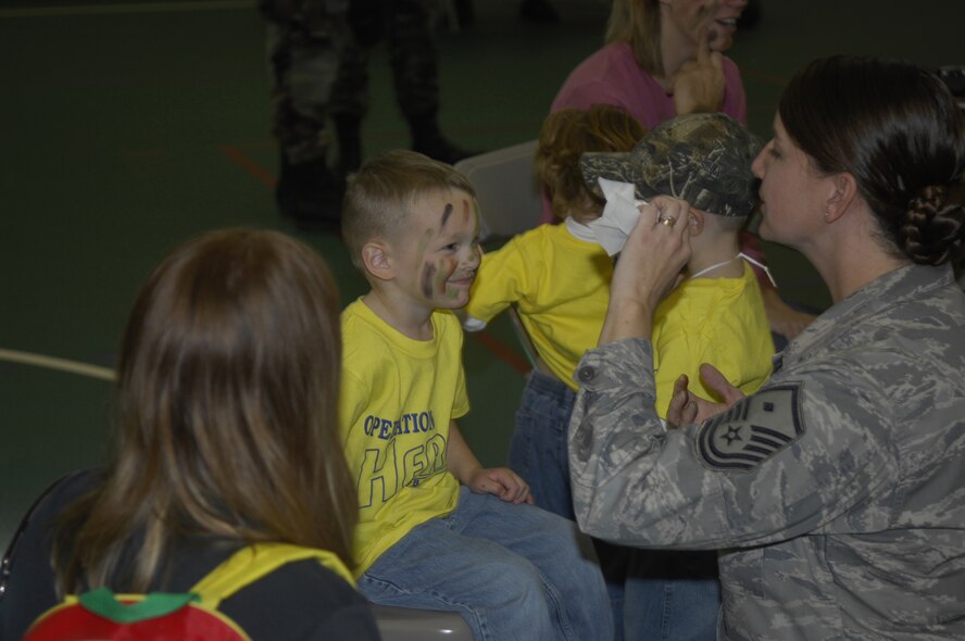 MINOT AIR FORCE BASE, N.D. – Master Sgt. Patrice Chandler, 5th Aircraft Maintenance Squadron first sergeant, paints the faces of children during the 2nd annual Operation HEROES here Oct. 21. The purpose of the Operation HEROES was to give children of deploying family members a better understanding of what their military parents go through in order to deploy. This year, more than 400 participated in the deployment to “KIDakastan.” (U.S. Air Force photo Senior Airman Joe Rivera)  