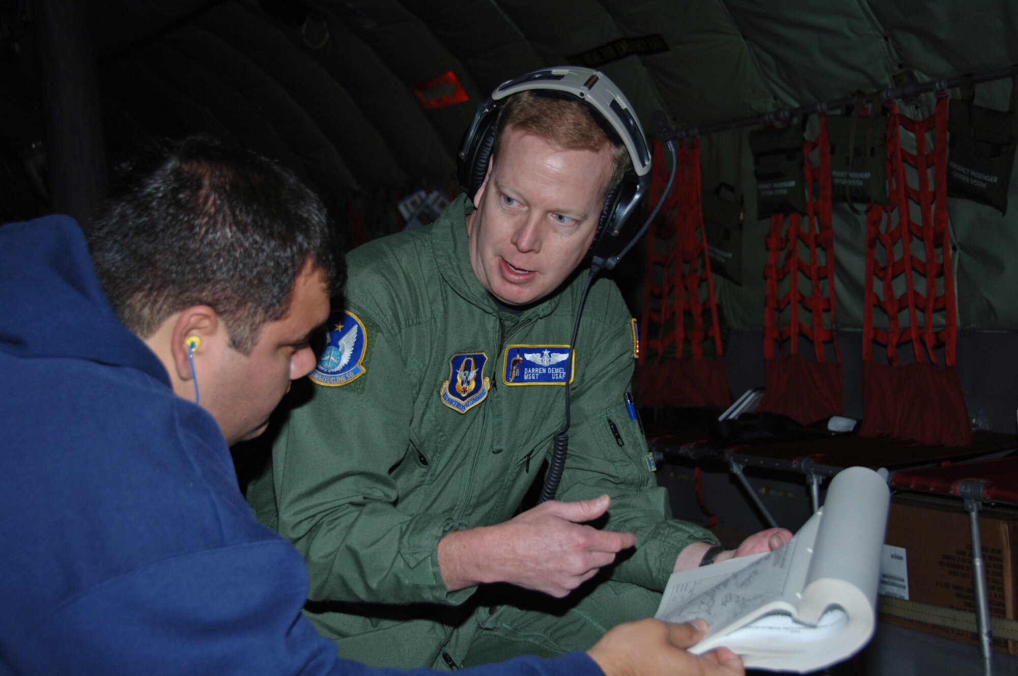 Master Sgt. Darren Demel shares information with a passenger during an air refueling mission on Oct. 18. Sergeant Demel is a KC-135 Statotanker boom operator for the 18th Air Refueling Squadron, the flying squadron of the 931st Air Refueling Group.  The 931st Air Refueling Group is an Air Force Reserve Command unit assigned to McConnell Air Force Base, Kan. (U.S. Air Force photo/Senior Airman Connor Burkhard)