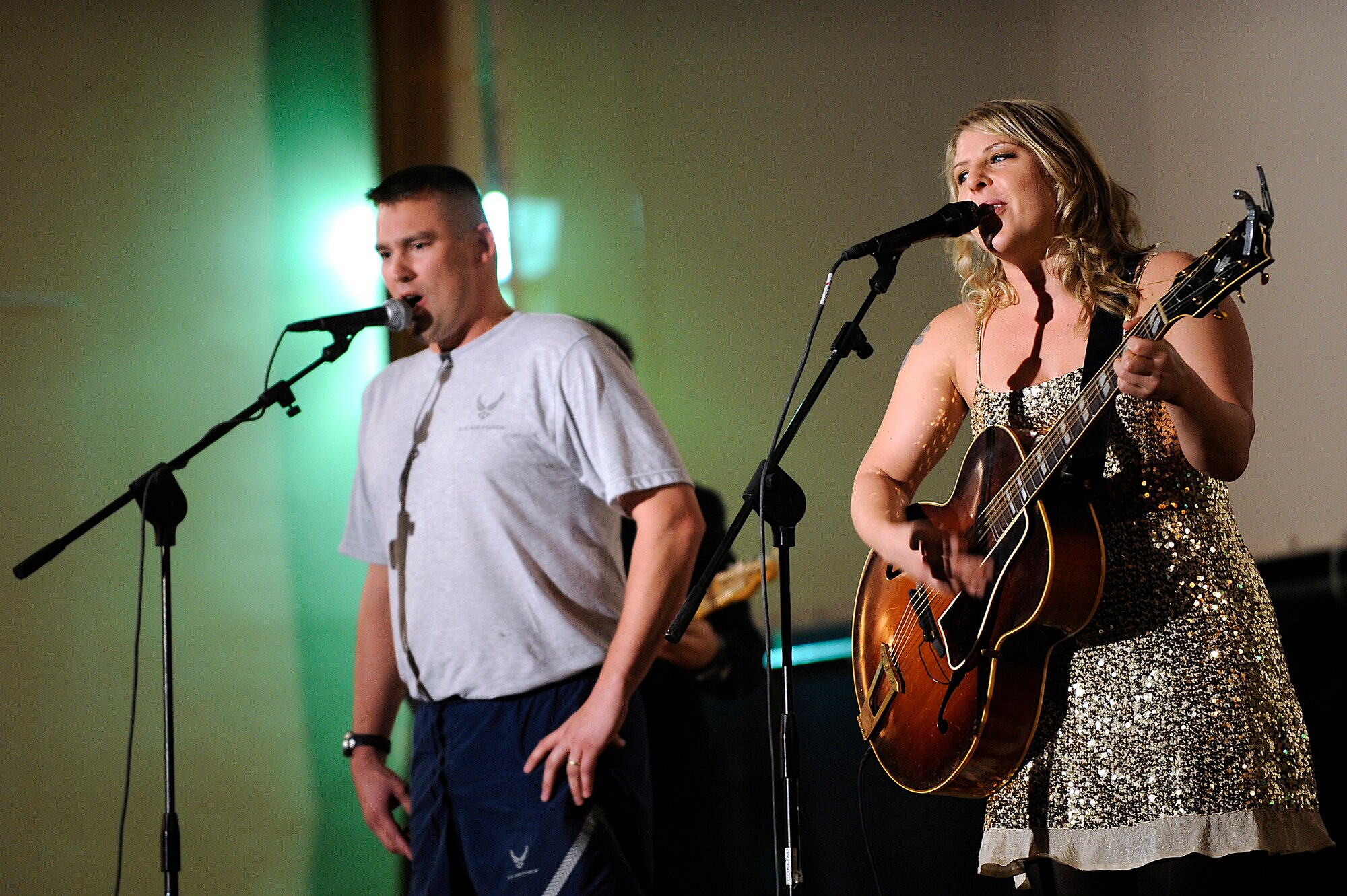 Nell Bryden, a jazz/bluegrass artist, coaxes an Airman from the audience to sing alongside her during a performance at Joint Base Balad, Iraq, Oct. 19. Bryden's performance was part of an Armed Forces Entertainment tour of the U.S. Central Command area of responsibility. Armed Forces Entertainment hosts more than 1,200 shows around the world each year. (U.S. Air Force photo/Airman 1st Class Jason Epley)