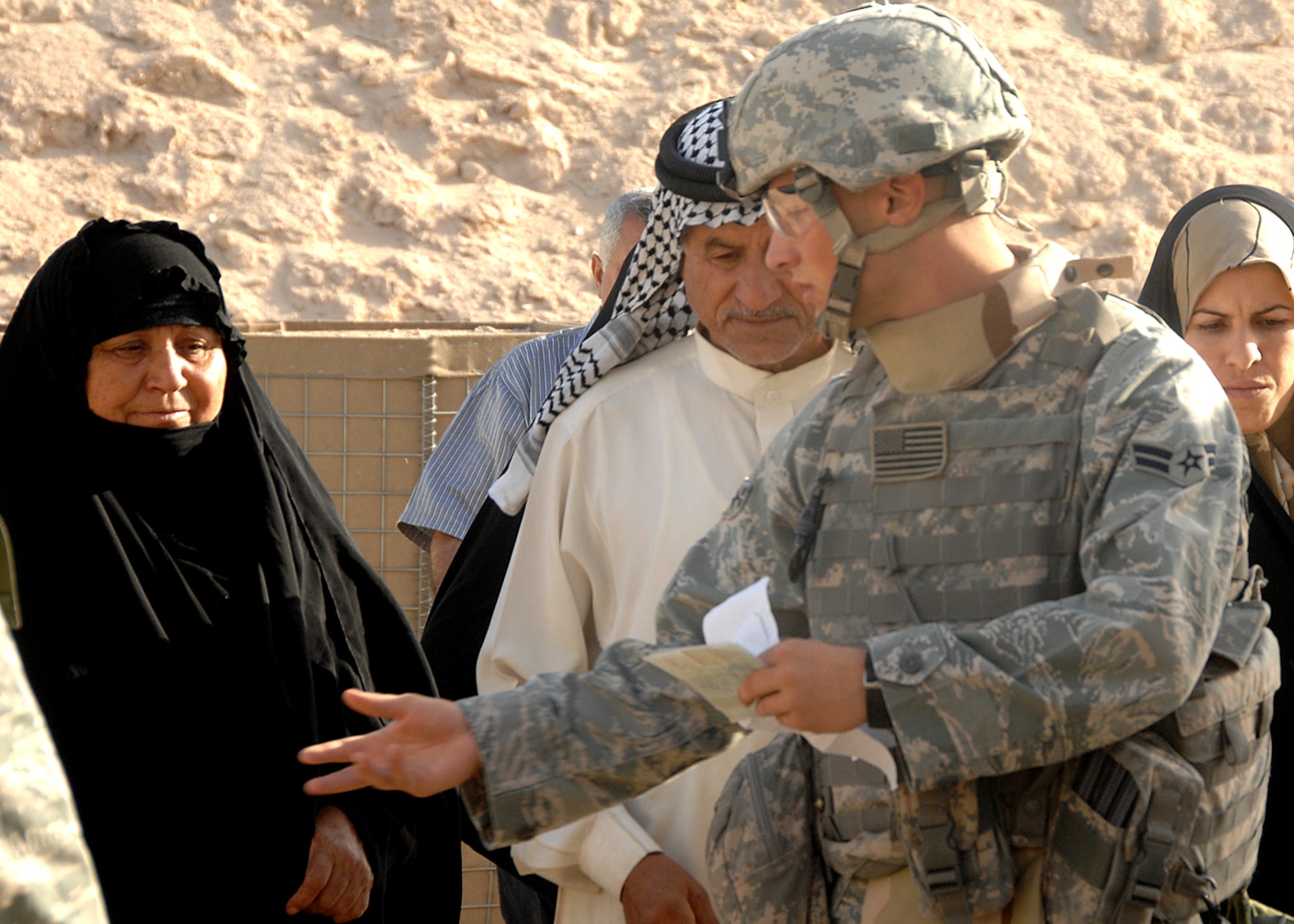 A security forces member assigned to the 586th Air Expeditionary Group escorts a group of Iraqi visitors to a security checkpoint Oct. 4 at Camp Bucca, Iraq. The 586th AEG provides security for the camp's visitation center, where nearly 400 visitors are allowed to visit daily with detainees being held at the theater internment facility. (U.S. Air Force photo) 
