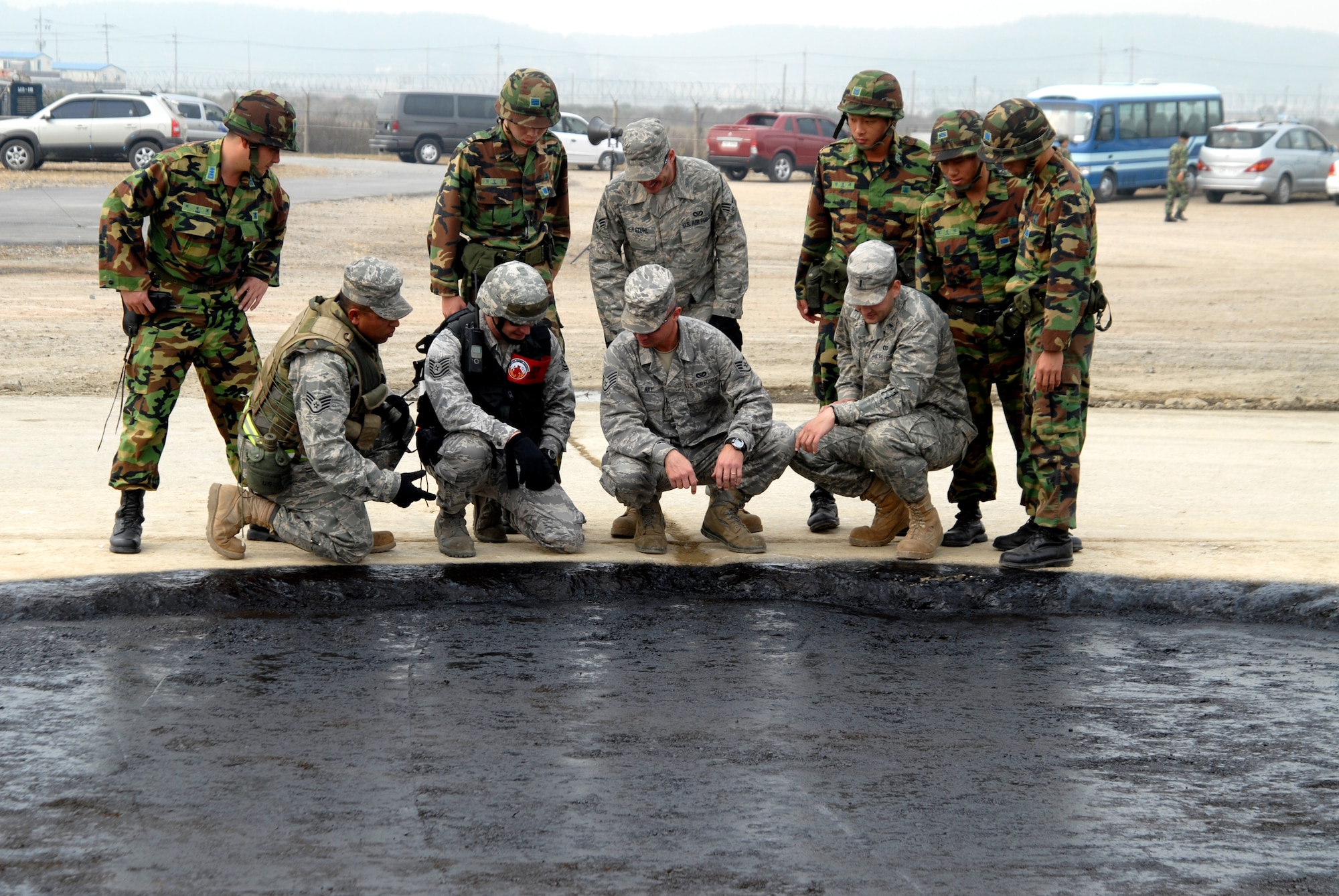 8th Civil Engineer Squadron Airman and Republic of Korea Air Forces' Airman inspect the job of a korean contractor before the final layer of asphalt is applied during a joint USAF/Republic of Korean Air Forces airfield management training at Kunsan Air Base, Republic of Korea, October 21, 2008. (U.S. Air Force photo/Staff Sgt. Jason Colbert)