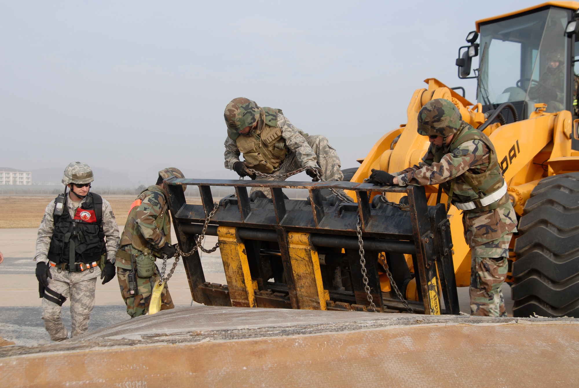8th Civil Engineer Squadron Airmen unhook a fiberglass cover from a piece of heavy loading equipment during a joint USAF/Republic of Korean Air Forces airfield management training at Kunsan Air Base, Republic of Korea, October 21, 2008. (U.S. Air Force photo/Staff Sgt. Jason Colbert)