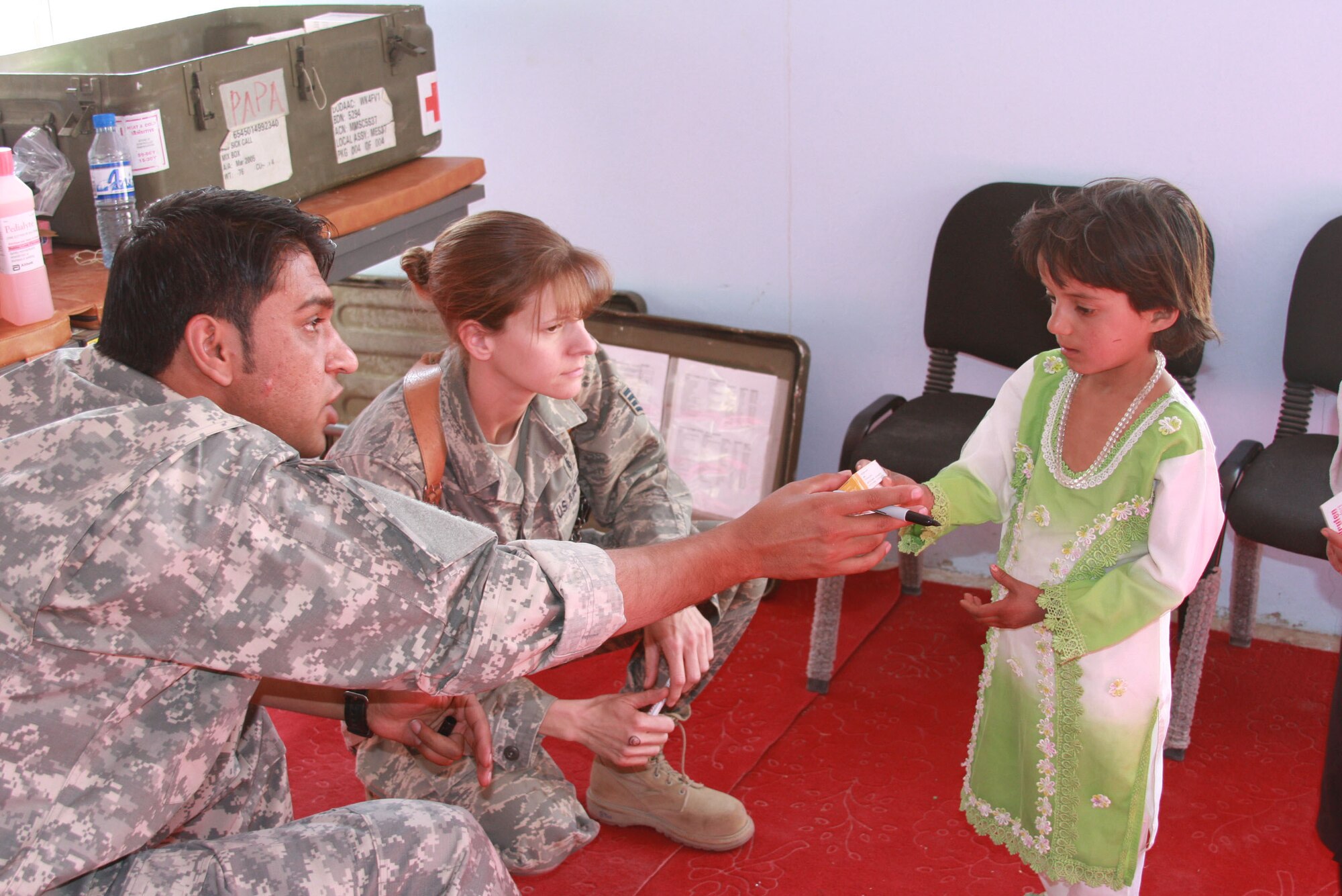 BAGRAM AIR FIELD, Afghanistan – Staff Sgt. Janine Duschka, a medic for PRT Panjshir, looks on while an interpreter explains medication dosages to a young girl during the medical engagement on Oct. 16 at Obdara clinic in Anaba District. 