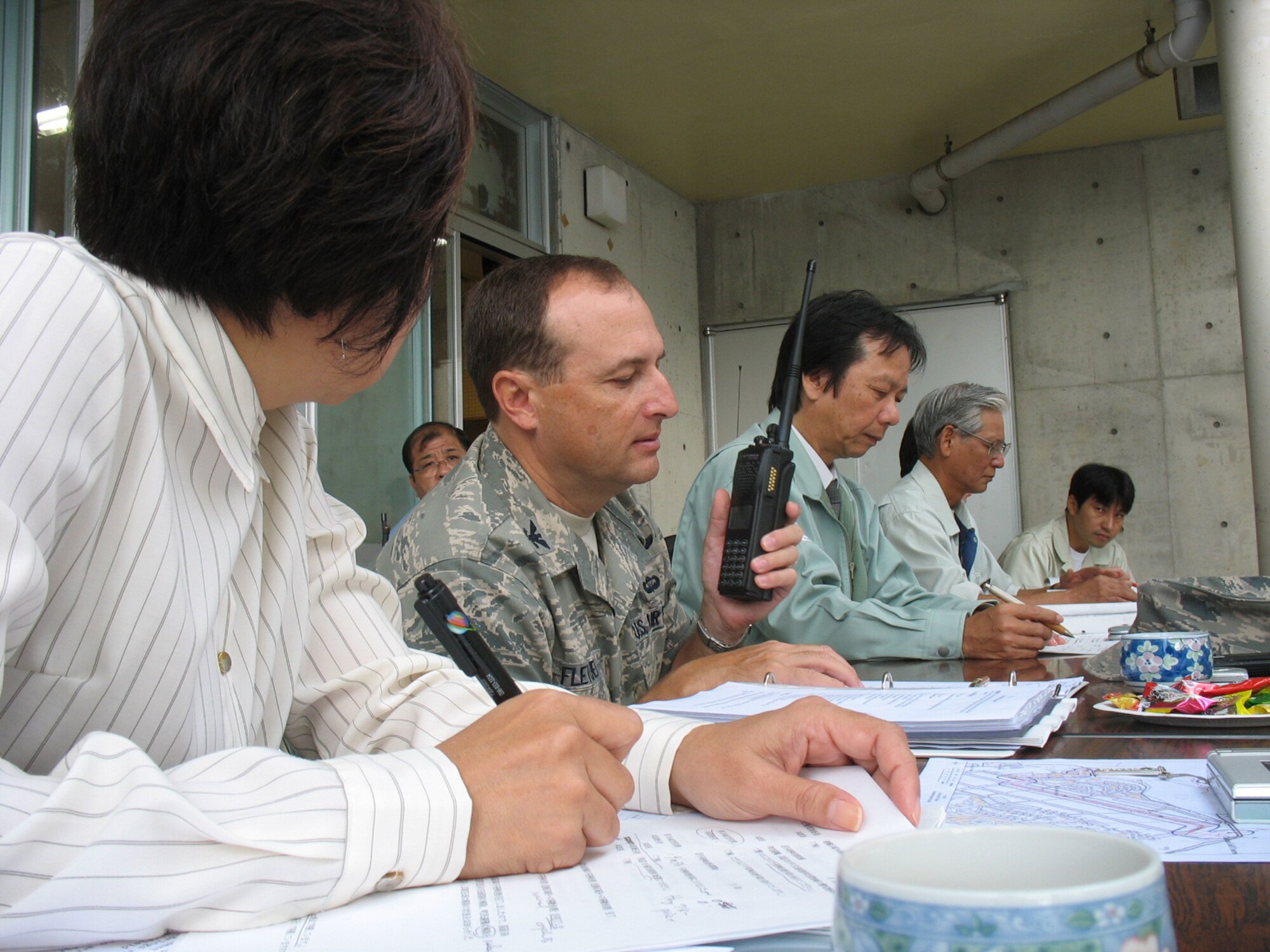 Col. Kelly Fletcher, 18th Mission Support Group commander, talks to the EOD team lead over the radio during a UXO disposal operation Oct. 19 at Kadena Air Base, Japan. Col. Fletcher, along with members of the 18th Security Forces Squadron and 18th Wing Public Affairs, worked out of the joint command center established by Kadena Town officials to coordinate the operation, which required evacuation of nearby off-base homes and a brief stoppage of traffic on Highway 58, which runs alongside the base. Kadena EOD specialists removed the UXO and destroyed it on the EOD range without incident. (U.S. Air Force photo/Maj. John Hutcheson)
