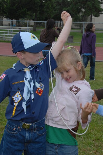 MISAWA AIR BASE, Japan -- Alyssa Bilger, daughter of Staff Sgt. Joseph Bilger, 35th Maintenance Squadron, and Sean Smyth, son of Lt. Col. Colin Smyth, 35th Medical Support Squadron commander, use teamwork to move the cord from one partner to the other without letting go of their hands during International Scout Day Oct. 11, 2008. More than 400 Japanese Boy and Girl Scouts attended the event. (U.S. Air Force photo by Senior Airman Laura R. McFarlane)