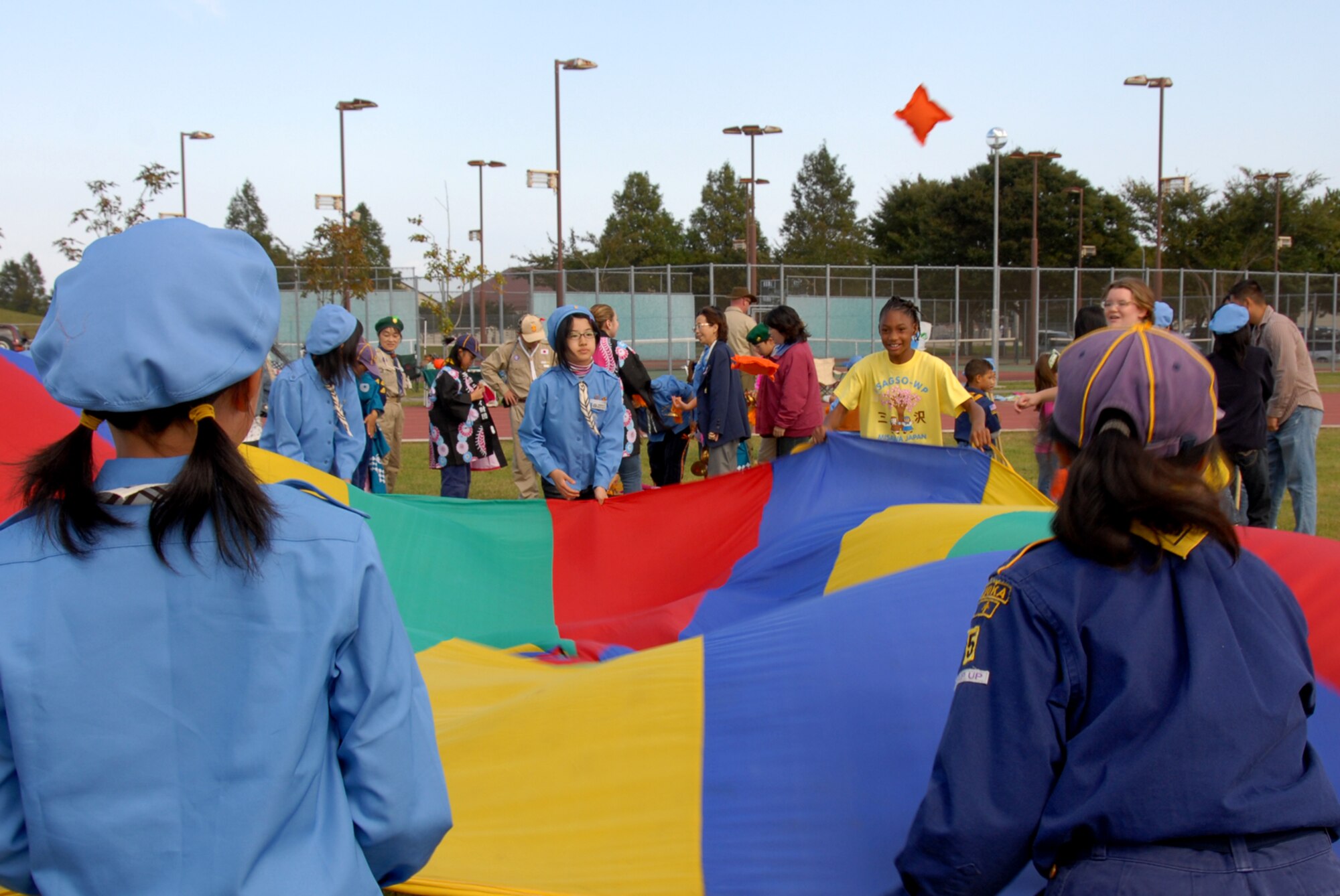 MISAWA AIR BASE, Japan -- Japanese and American Girl Scouts participate in a parachute game during International Scout Day Oct. 11, 2008. The object of the game is to use a waving motion to toss bean bags through a hole in the center of the parachute. (U.S. Air Force photo by Senior Airman Laura R. McFarlane)
