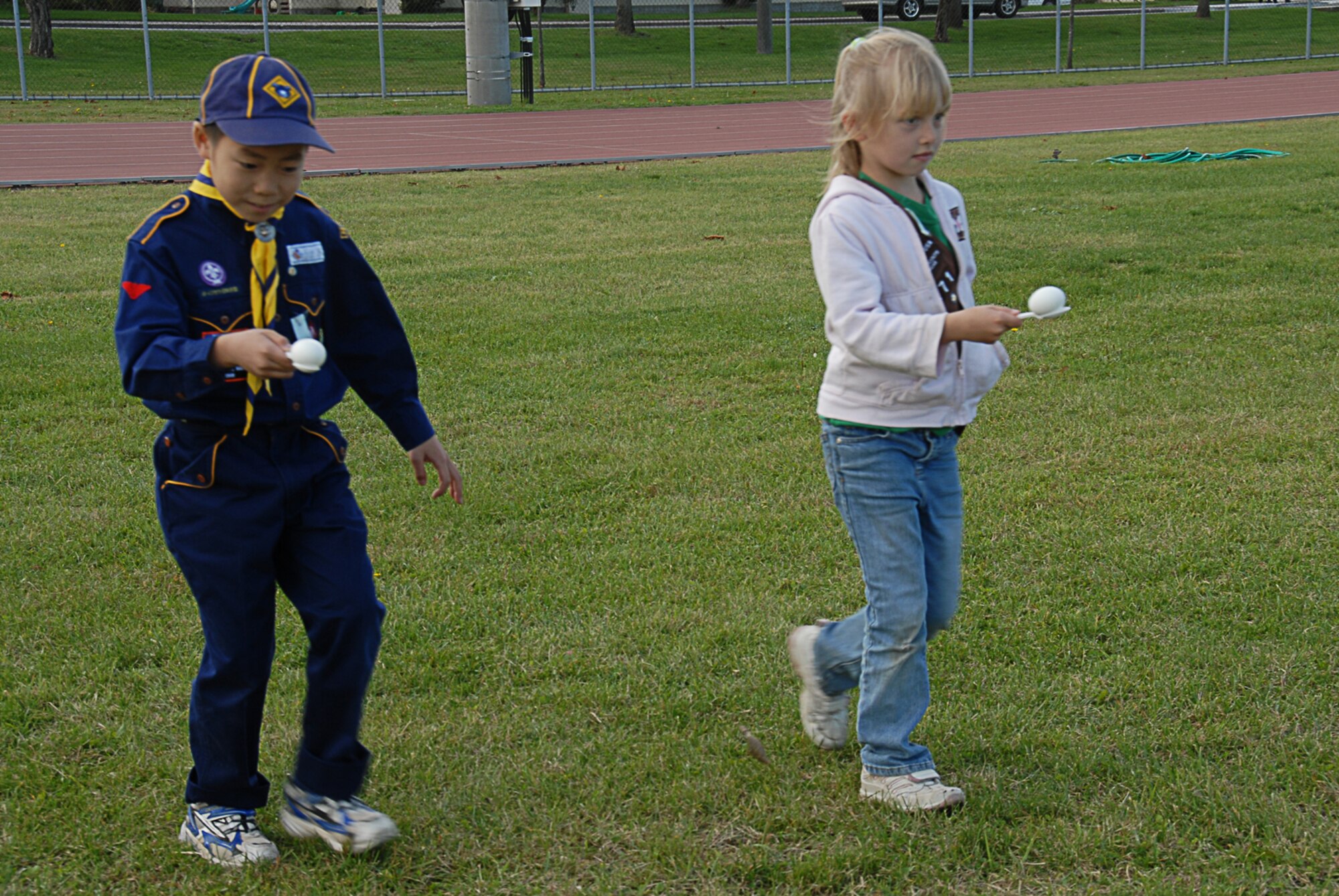 MISAWA AIR BASE, Japan -- Kou Shiraiwa, a student from the Kamikubo Elementary School in Misawa City and Alyssa Bilger, a student from Sollars Elementary School, compete in an egg relay race during International Scout Day Oct. 11, 2008. The event is hosted at Misawa Air Base to give Japanese and American children an opportunity to interact. (U.S. Air Force photo by Senior Airman Laura R. McFarlane)