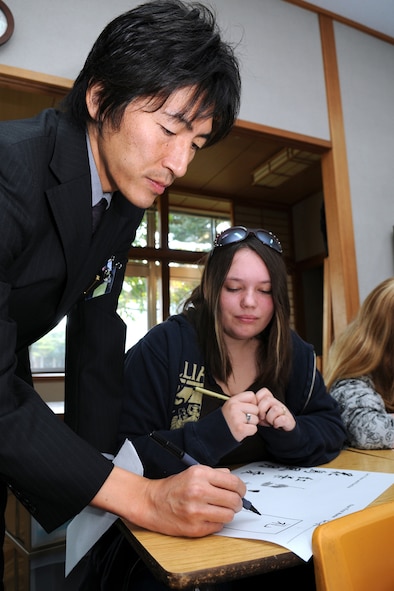 MISAWA AIR BASE, Japan -- Mr. Fuminor Nakaya demonstrates calligraphy to Alexandra Statia, Oct. 21, 2008, during educators day at Edgren High School. Mr. Nakaya is a Hokuryo Junior High School English teacher from Hachinohe City. (U.S. Air Force photo by Airman 1st Class Jamal D. Sutter)