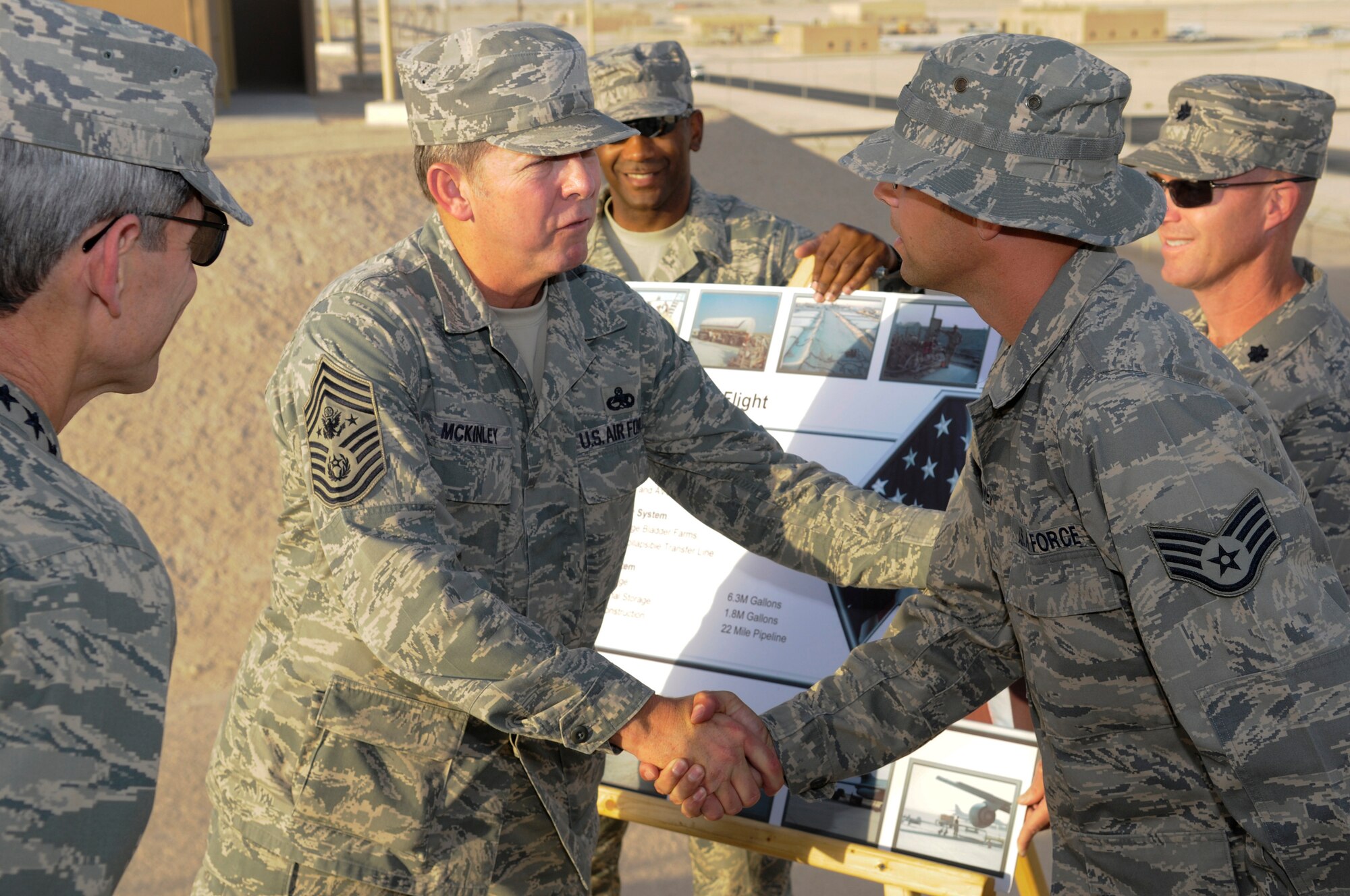 Chief Master Sergeant of the Air Force Rodney McKinley coins Staff Sgt. Matthew Cramer for his work as a bulk fuels storage attendant with the 379th Expeditionary Logistics Readiness Squadron.   Sergeant Cramer briefed the Chief Master Sergeant of the Air Force and Air Force Chief of Staff Gen. Norton Schwartz Oct. 20, during a visit to their location.  The visit marked the CSAF's first trip to the U.S. Air Forces Central area of responsibility since his appointment as the Air Force chief of staff. (U.S. Air Force photo by Tech. Sgt. Michael Boquette/Released)