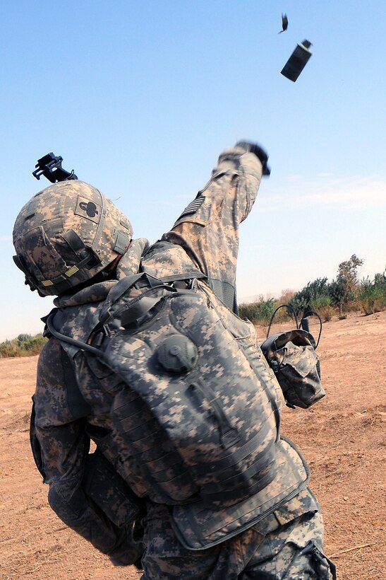 A U.S. Army soldier throws a smoke grenade during an air assault near the banks of the Tigris River, Bayji, Iraq, Oct. 14, 2008.