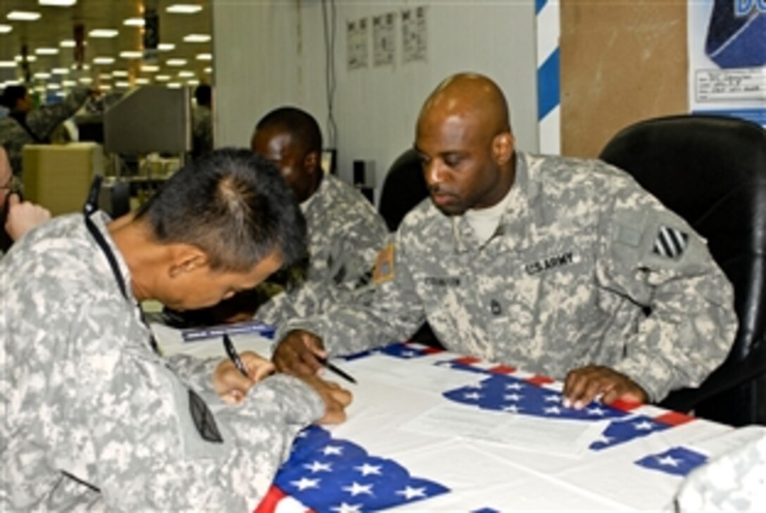 U.S. Army Sgt. 1st Class Cedric Covington, Headquarters & Headquarters Company, 4th Brigade Combat Team, 3rd Infantry Division, helps soldiers register to vote at the dining facility on Forward Operating Base Kalsu, in Iraq, Oct. 17, 2008. 
