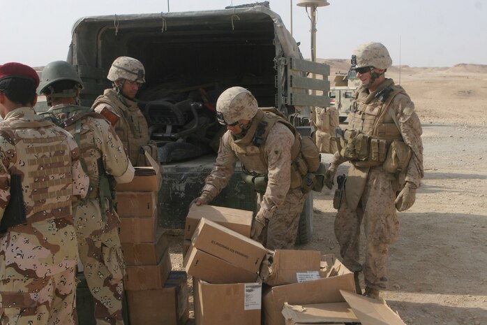 Marines with the Baghdadi Military in Transition Team, which is assigned to the 3rd Battalion, 2nd Iraqi Brigade, 7th Iraqi Division, unload boxes of school supplies at Khasfah, Iraq, Oct. 21. Iraqi soldiers distributed the supplies to the children at an elementary school. Marines with the Baghdadi MITT work with the Iraqi Army to help facilitate them in their operations as they now play a more prominent role in Iraqi security.