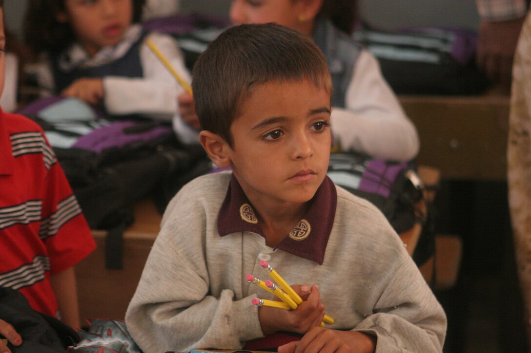 An Iraqi boy holds his pencils and looks to see what else the Iraqi Army will be giving at an elementary school in Khasfah, Iraq, Oct. 21. Several organizations back in the states sent school supplies to the Marines with the Baghdadi Military in Transition Team, which is assigned to 3rd Battalion, 2nd Iraqi Brigade, 7th Iraqi Division. The Marines then turned them over to the IA to be distributed to schools.
