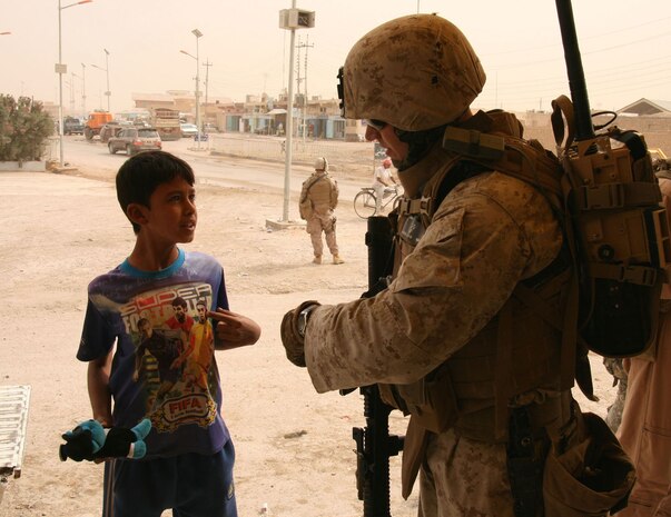 Lance Cpl. Michael Aylward, 24, of Hanover, Mass., gives a stuffed animal to a boy while on patrol in Rutbah, Iraq, Oct. 21.  Aylward, a recent graduate of Fairfield University in Connecticut, is an infantryman with Weapons Company, 2nd Battalion, 25th Marine Regiment, Regimental Combat Team 5.