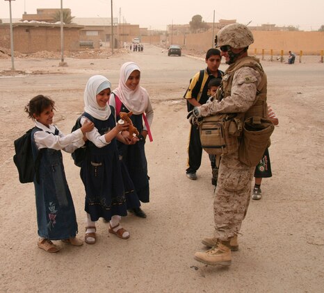 A Active Reserve Marine from 2nd Battalion, 25th Marine Regiment, Regimental Combat Team 5 gives stuffed animals to children on their way home from school in Rutbah, Iraq, Oct. 21, 2008.  The toys were donated and mailed to Iraq by citizens from throughout the United States.  The Marines in the battalion distributed these toys to children in Rutbah while on Patrol Oct. 22-24.