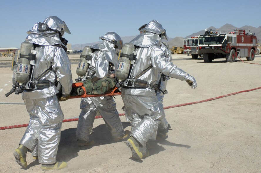 CREECH AFB, Nev. -- Creech AFB Fire Department, Firefighters, carry Airman 1st Class Bryson Hill, 432d Aircraft Maintenance Squadron to an ambulance during a Major Accident Response Exercise here Oct. 14. The 432d Wing conducted the MARE to test response capabilities at the base. (U.S. photo/Airman 1st Class Stephanie Rubi) 
