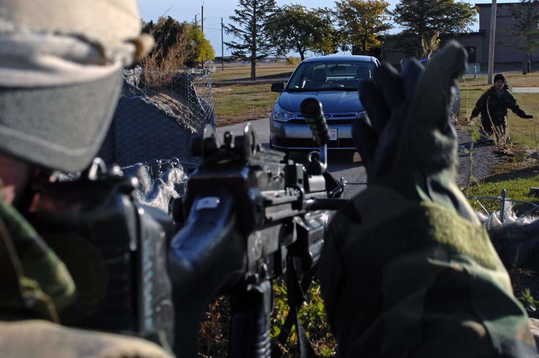 Senior Airman Alexander Mendes directs Senior Airman Tran Hoang to stand up during an exercise here, Oct. 22. Senior Airman Hoang simulated terrorist activity in the exercise; both Airmen are 28th Security Forces Squadron police officers. (U.S. Air Force photo/Airman Corey Hook)
