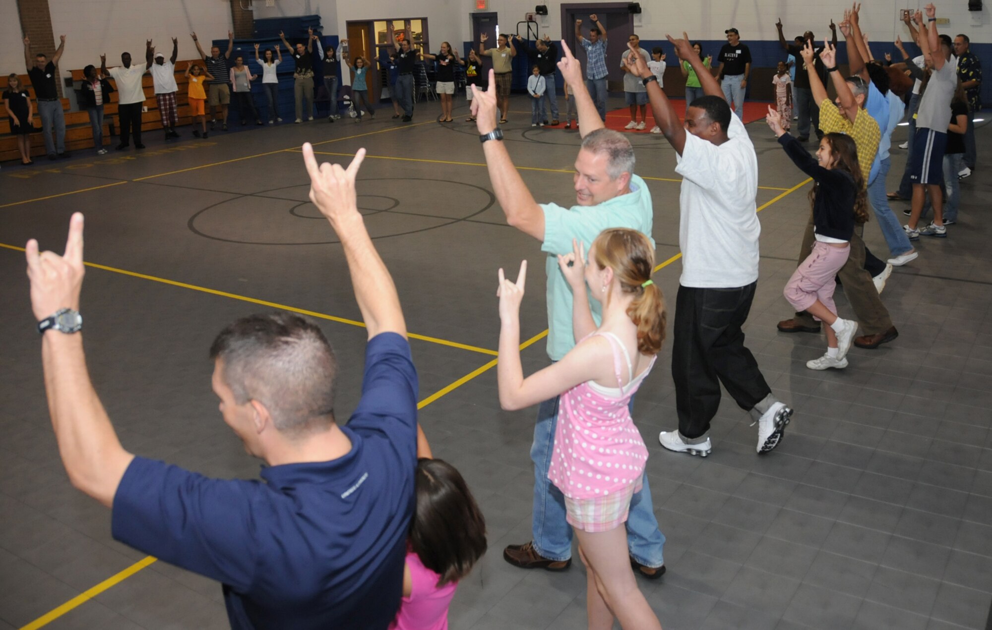 Fifty dad-and-daughter couples participate in an ice-breaker at “Because We Have Daughters,” a free workshop Saturday at the youth center.  The event was designed to strengthen father/daughter relationships, boost communication skills and address safety and self-esteem challenges that girls face.  The program was sponsored by family advocacy.  (U.S. Air Force photo by Kemberly Groue)