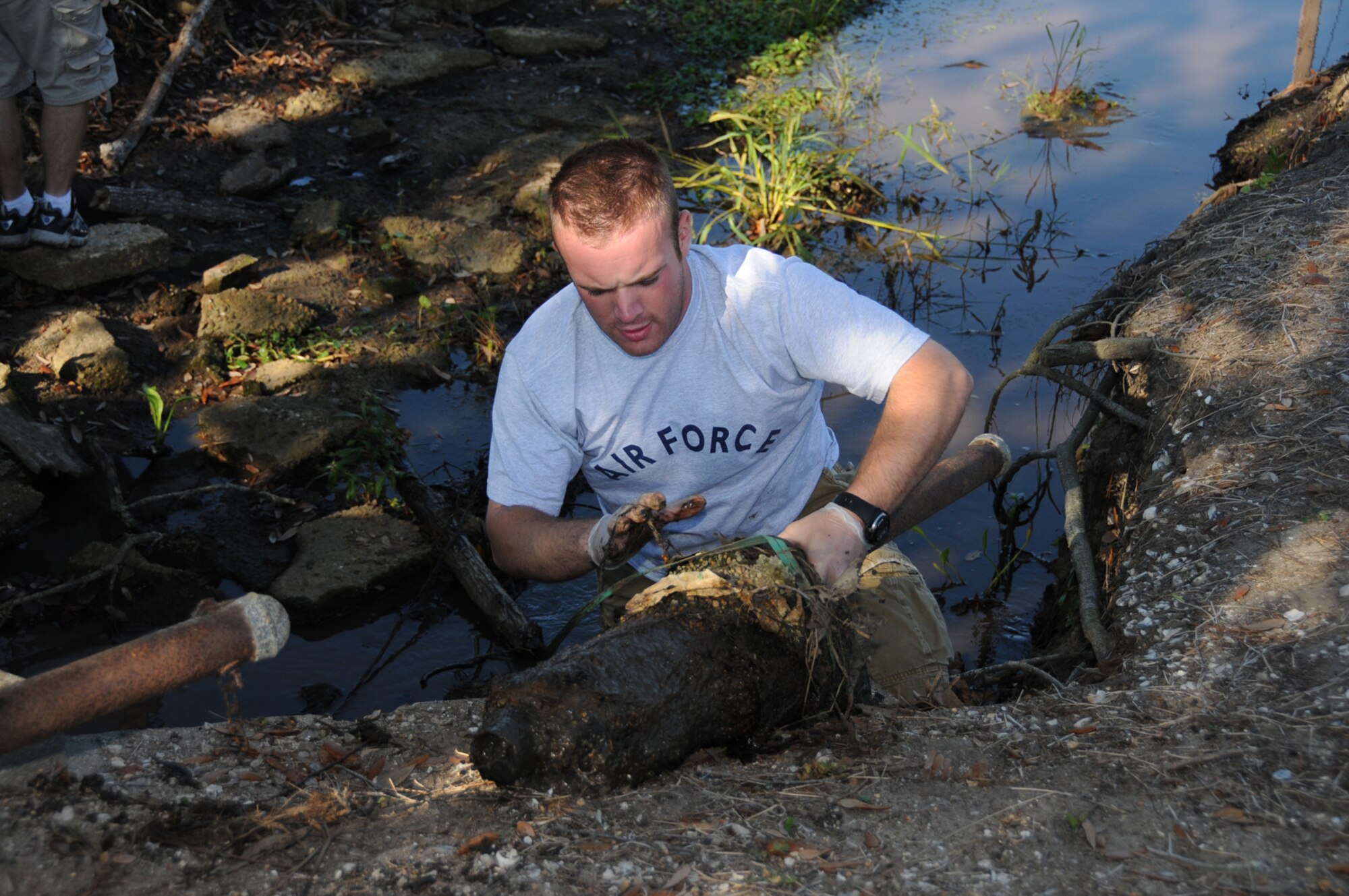 Airman Basic Matthew Walmsley, a student in the 332nd Training Squadron, cleans debris out of a ditch in Biloxi’s Hiller Park Saturday as part of the 20th annual Mississippi Coastal Cleanup.  More than 200 base volunteers focused their efforts on Hiller Park and Keesler Marina Park.  In the three coastal counties and barrier islands along the Mississippi Gulf Coast, more than 2,224 volunteers collected 2,625 bags of trash along 173 miles of coastal waterways.  (U.S. Air Force photo by Kemberly Groue)