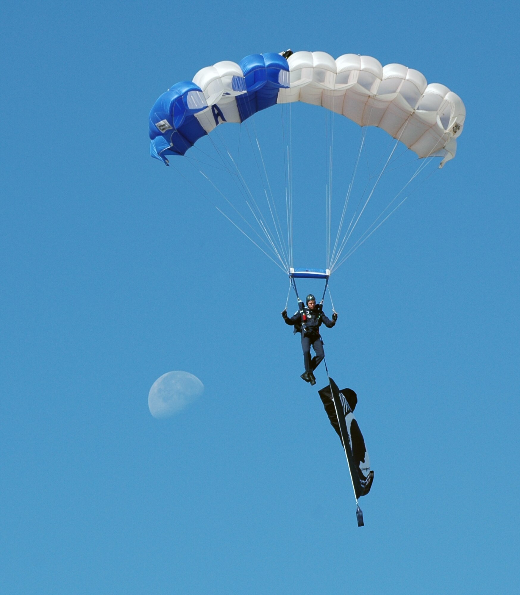 An Air Force Academy Wings of Blue parachutist makes his descent to the
Dobbins' airfield carrying a POW/MIA flag while a partial moon is sighted in the background. Dobbins hosted the 2008 Wings Over Marietta Air Show Oct. 18-19, which featured an F-22 Raptor demo and the U.S. Air Force Thunderbirds. (Air
Force photo/Senior Airman Shaun Shenk)