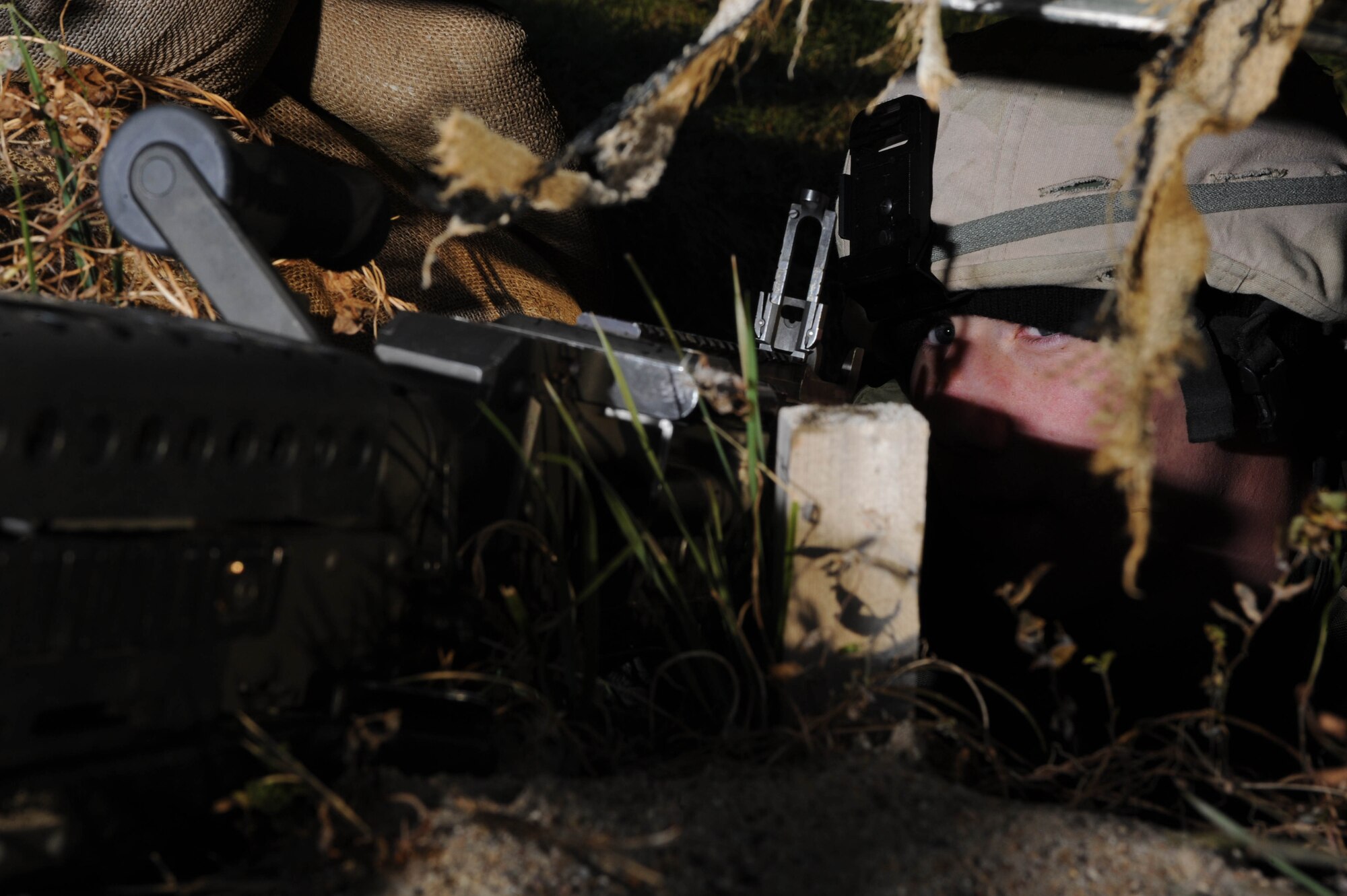 Airman 1st Class Chadwick Richardson, 28th Security Forces Squadron member, provides cover in a Defense Fighting Position during an exercise held here Oct. 22.  The Defense Fighting Position provides front line perimeter security with interlocking fields to protect resources from all directions. (U.S. Air Force photo/Airman 1st Class Adam Grant)  