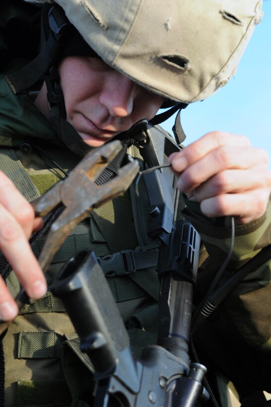 Airman 1st Class Jeffery Yates, 28th Security Forces Squadron member, sets up ground communication wire during an exercise held here Oct. 22. The wire  is used to connect secure phone lines, which can be controlled from a switch board. The exercise was designed to train SFS Airmen on the various scenarios that take place while deployed. (U.S. Air Force photo/Airman 1st Class Adam Grant)  

