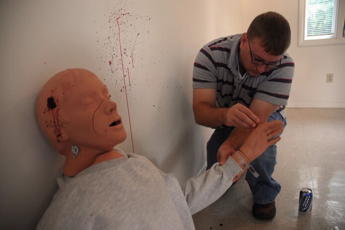Timothy Boggs takes samples from the victim's hands for gunshot residue analysis during a crime scene investigation exercise which simulated a suicide in base housing Oct. 17. The local Office of Special Investigations detachment held the exercise to test their CSI skills and work with their counterparts in the 437th Security Forces Squadron and the 437th Airlift Wing Law Center. Mr. Boggs is a civilian flight chief with the 437 SFS.  (U.S. Air Force photo/Staff Sgt. Sam Hymas)
