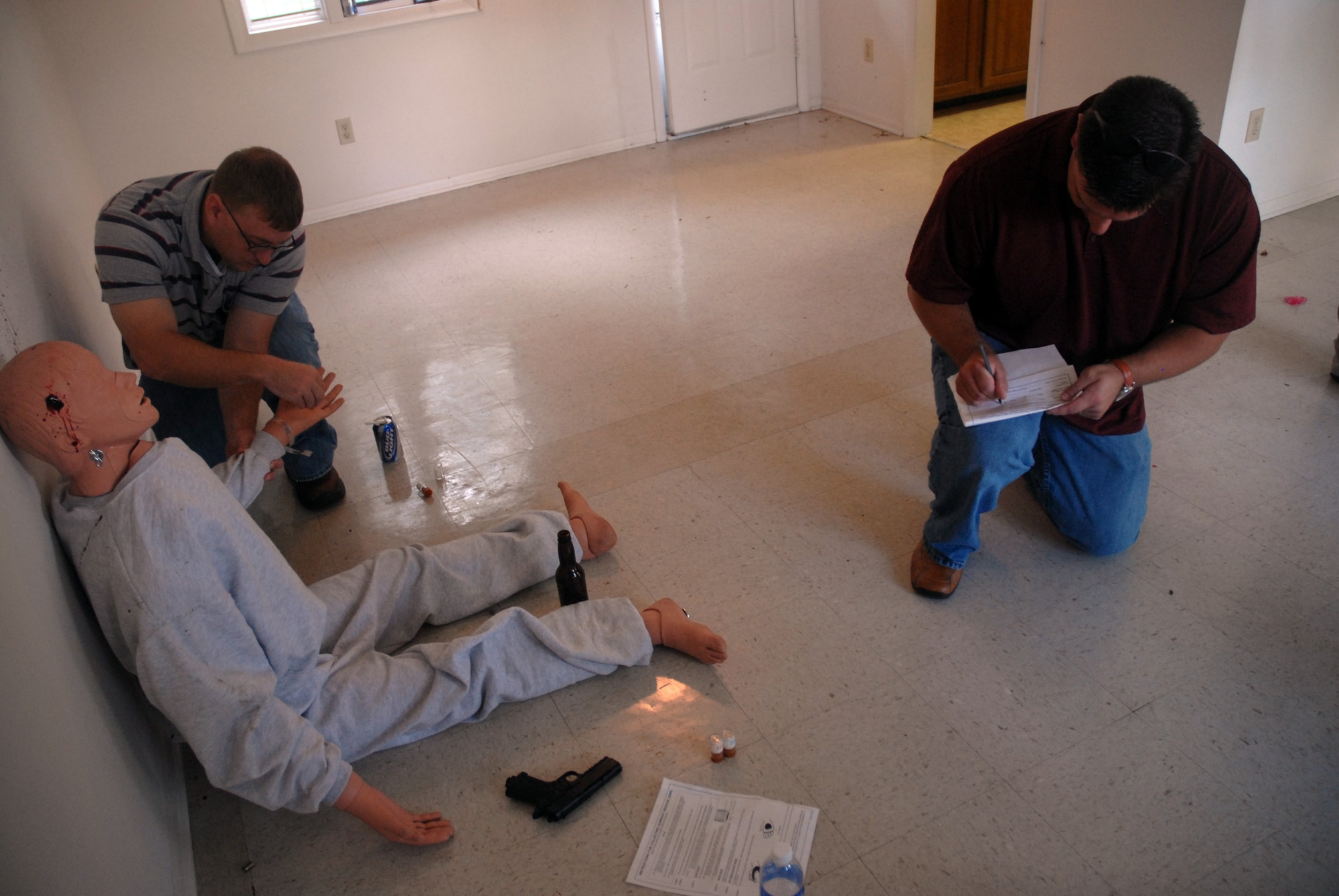 Timothy Boggs takes samples from the victim's hands for gunshot residue analysis while Ed White fills out additional paperwork during a crime scene investigation exercise which simulated a suicide in base housing Oct. 17. The Air Force Office of Special Investigations Detachment 310 held the exercise to test their CSI skills and work with their counterparts in the 437th Security Forces Squadron and the 437th Airlift Wing Law Center. Mr. Boggs and Mr. White are civilian flight chiefs with the 437 SFS.  (U.S. Air Force photo/Staff Sgt. Sam Hymas)