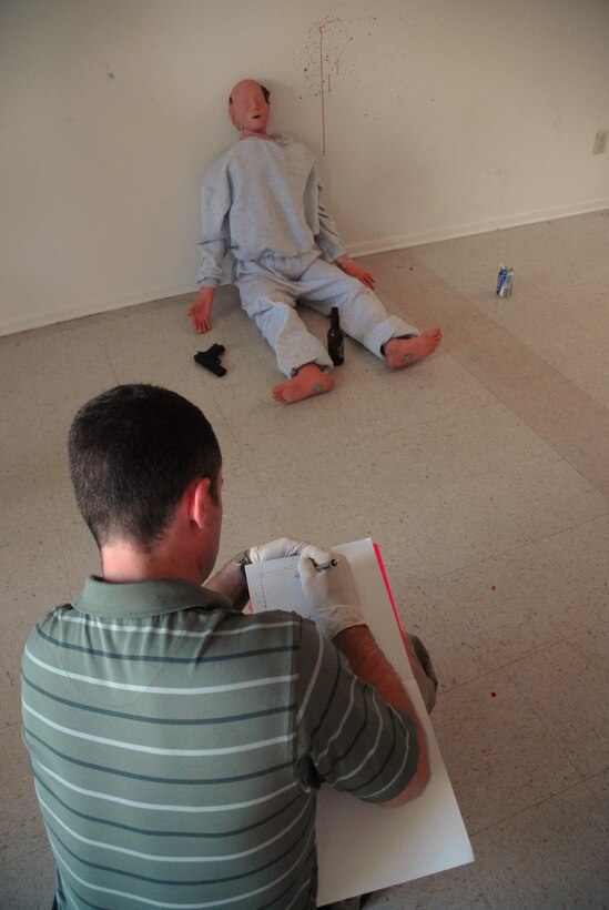 Special Agent Jeremy Meng sketches the crime scene during an exercise in base housing Oct. 17. The Air Force Office of Special Investigations Detachment 310 held an exercise simulating a suicide to test their crime scene investigation skills. The suicide victim was a CPR dummy on loan from the 437th Medical Group. Agent Meng is assigned to AFOSI Det. 310. (U.S. Air Force photo/Staff Sgt. Sam Hymas)