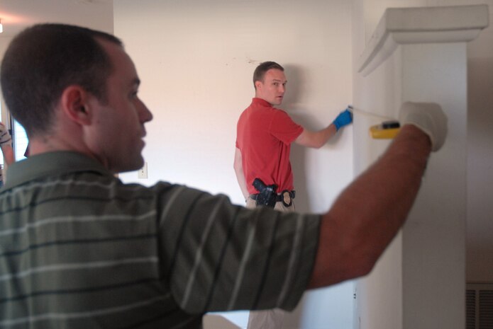 Special Agents Jeremy Meng and Matthew Tonay measure the dimensions of the room during a crime scene investigation exercise in base housing Oct. 17. The Air Force Office of Special Investigations Detachment 310 held an exercise simulating a suicide to test their CSI skills and work with their counterparts in the 437th Security Forces Squadron and the 437th Airlift Wing Law Center. Agents Meng and Tonay are assigned to AFOSI Det. 310.(U.S. Air Force photo/Staff Sgt. Sam Hymas)