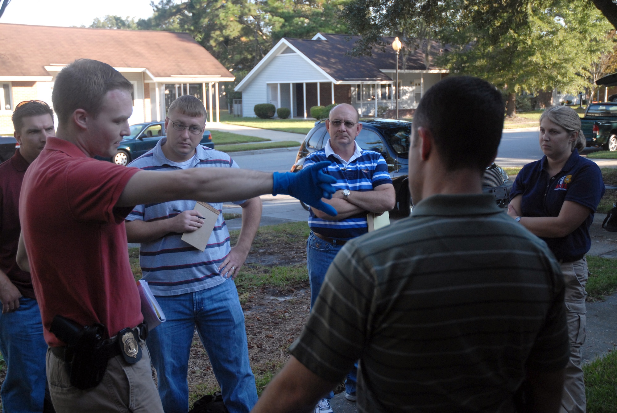 After a brief inspection of the exercise crime scene, Special Agent Matthew Tonay briefs investigation team members about details on the scene prior to completing a full investigation in base housing Oct. 17. The Air Force Office of Special Investigations Detachment 310 put together an exercise to test their investigatory preparedness and to work with their counterparts with the 437th Security Forces Squadron and the 437th Airlift Wing Law Center. Agent Tonay is assigned to AFOSI Det. 310. (U.S. Air Force photo/Staff Sgt. Sam Hymas)