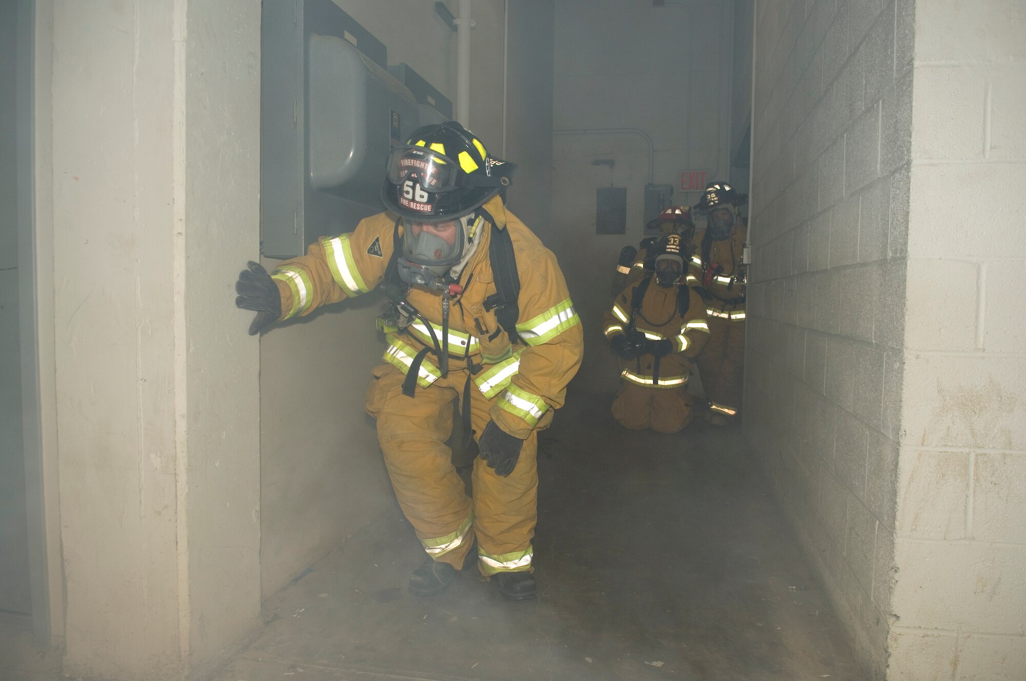 HANSCOM AIR FORCE BASE, Mass. –Fireman Tim Shea (left) assesses a simulated fire in the basement of building 1102F, while Firemen Kevin Tanguay (kneeling), Capt. Dan Stone, and Keith Williams (right), wait for the signal to proceed.  The simulated fire and explosion was part of the base’s week-long readiness exercises to get ready for the Unit Compliance Inspection, Targeted Readiness Inspection that will take place from Nov. 1 -10. (U.S. Air Force photo by Rick Berry)