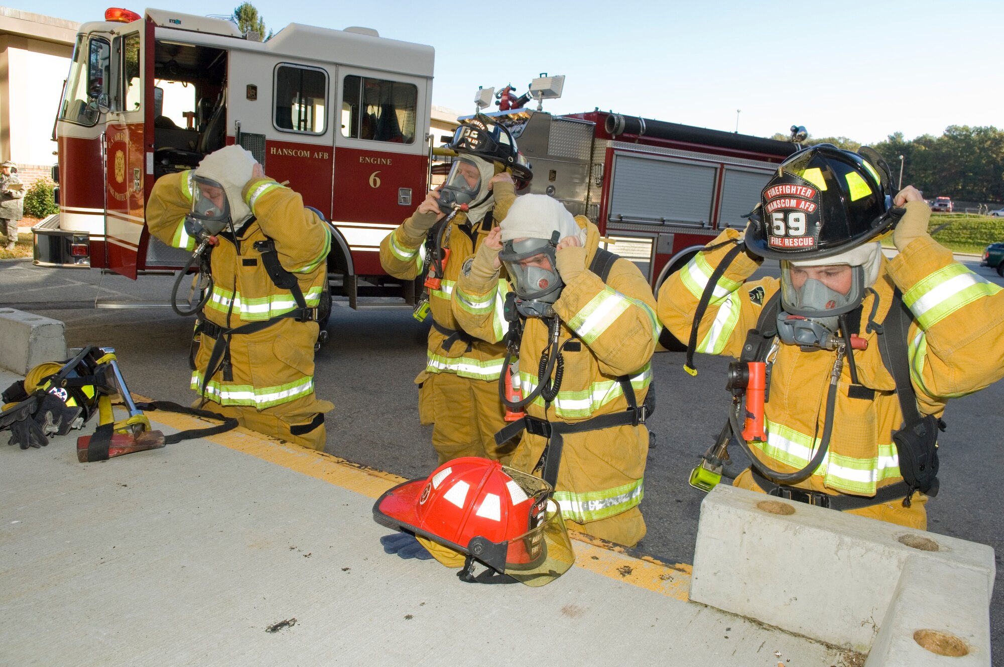 HANSCOM AIR FORCE BASE, Mass. –Hanscom firemen get suited up to respond to a simulated fire, explosion in building 1102F, during an emergency management exercise on Oct. 20. In addition to the emergency operations exercise, more than 230 personnel took part in readiness training at Camp Patriot in preparation for the start of next week’s Unit Compliance and Targeted Readiness Inspections. (U.S. Air Force photo by Rick Berry)