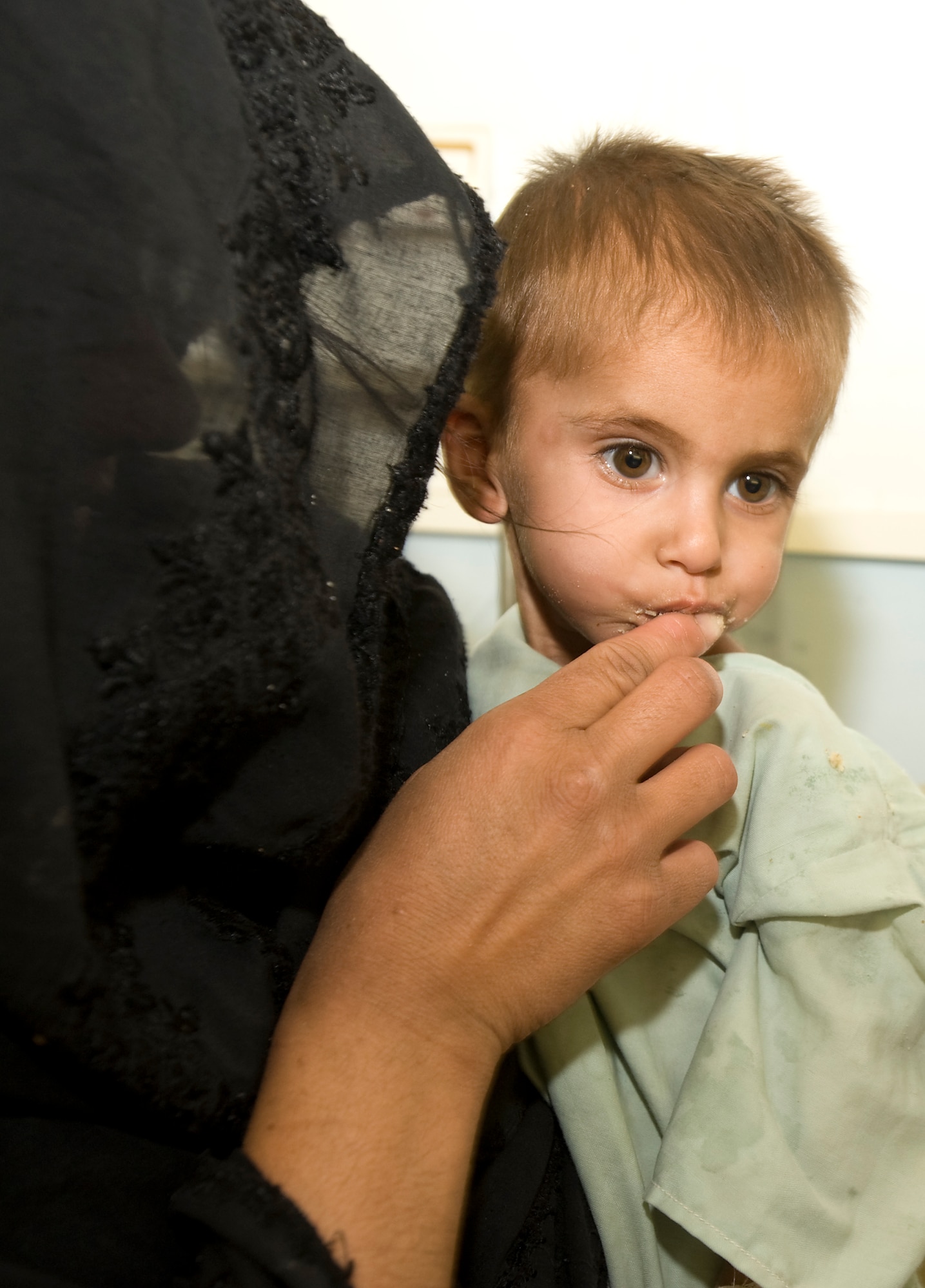 SHAJOY. Afghanistan -- An Afghan mother gives her daughter a taste of "strong food" a vitamin enriched and calorie heavy supplement. The Zabul Provincial Reconstruction Team is working with local heath officials to combat the main causes of the areas extremely high infant mortality. The Shajoy public health administration staff has been using the low-cost and locally produced food supplement to treat more than 400 malnourished children in two months. The doctor said he has seen most patients gain 1 to 1.5 kilograms a week while taking “strong food.” (U.S. Air Force photo/Master Sgt. Keith Brown)