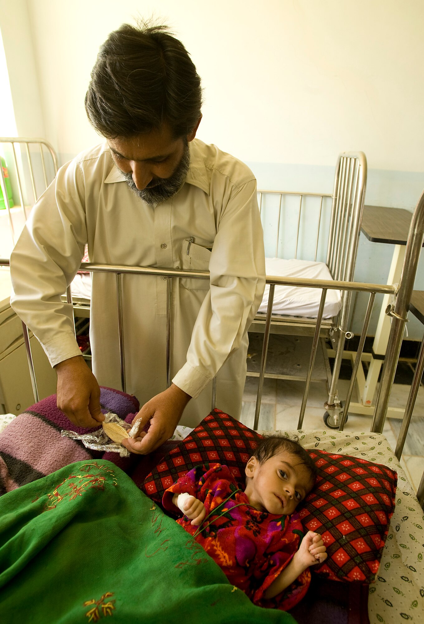 SHAJOY. Afghanistan -- Dr. Zamarai Sultan begins treating a malnourished Afghan child with "strong food" a vitamin enriched and calorie heavy supplement. The Zabul Provincial Reconstruction Team is working with local heath officials to combat the main causes of the areas extremely high infant mortality. The Shajoy public health administration staff has been using the low-cost and locally produced food supplement to treat more than 400 malnourished children in two months. The doctor said he has seen most patients gain 1 to 1.5 kilograms a week while taking “strong food.” (U.S. Air Force photo/Master Sgt. Keith Brown)