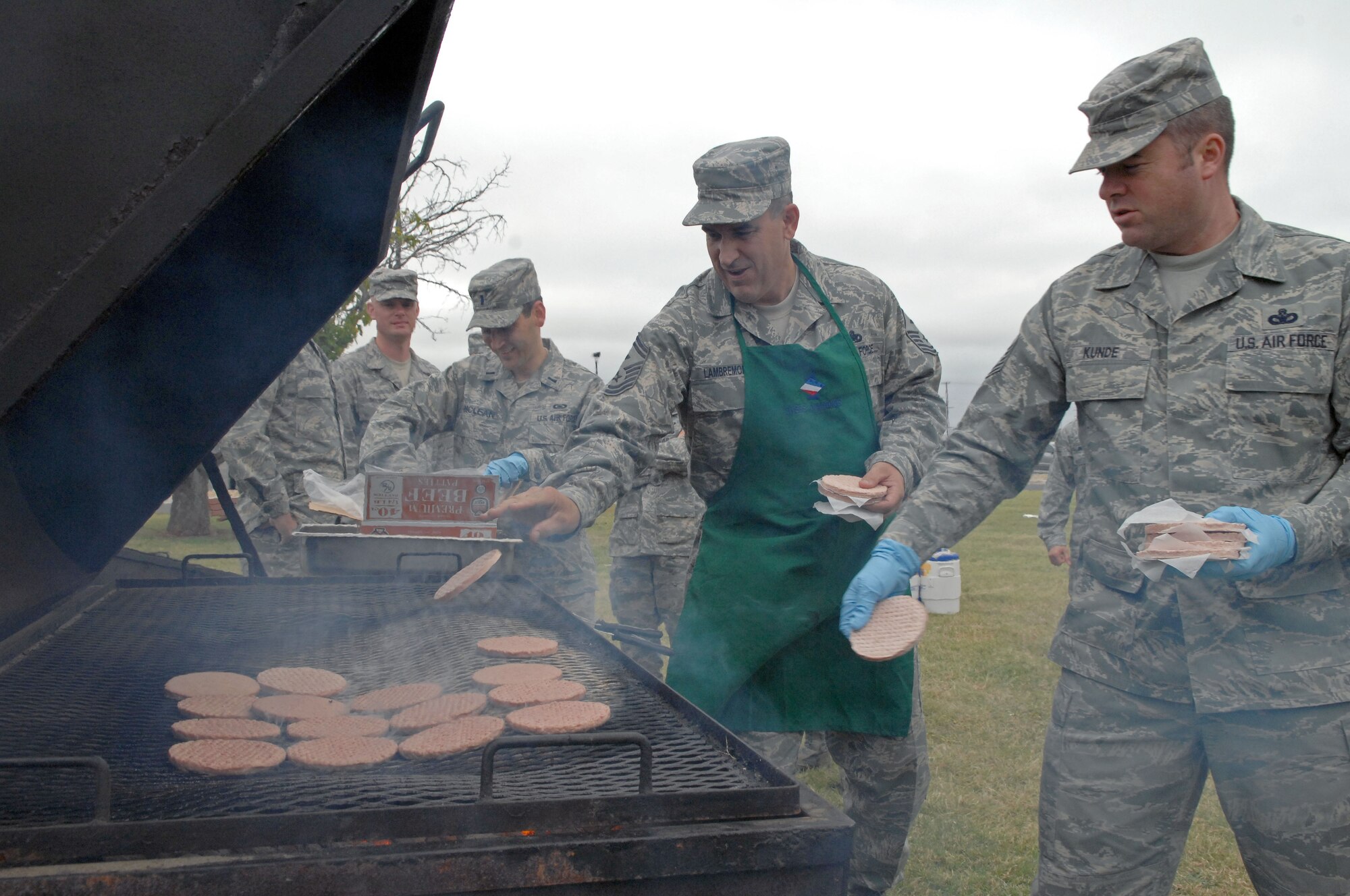 DYESS AIR FORCE BASE, Texas – First sergeants Master Sgt. Benjamin Kunde (right), 7th Munitions Squadron, and Senior Master Sgt. Theodore Lambremont, 7th Equipment Maintenance Squadron, together with other base volunteers, throw some burgers on the grill at the base parade grounds Oct. 15 to kick off the 2008 Combined Federal Campaign.  Dyess personnel showed their support and generosity at the Combined Federal Campaign burger burn Oct. 15 by donating $3,337 to local and international charities, bringing the total amount raised during week No. 1 to $16,476 or nine percent of the campaign goal.  (U.S. Air Force photo/Staff Sgt Connor Estes)