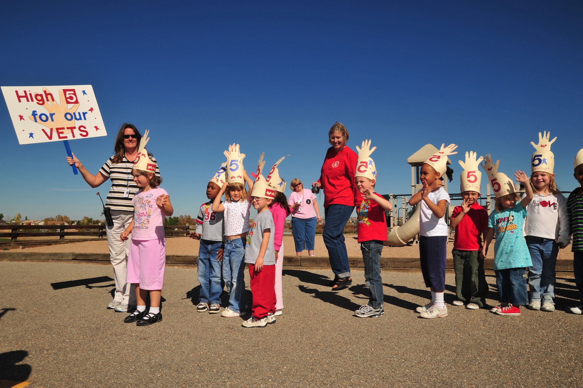 Kindergarteners in an after school program at Sunrise Elementary School in Aurora, Colo., give high fives to veterans during the school?s Veterans Day parade at Oct. 17, 2008. The children are being led by Karen Allen (far left) and Tracy Clough (center, in red). The school is hosting its fifth annual parade to honor former and current members of the U.S. armed forces. Current members of the 140th Wing, Colorado Air National Guard, from Buckley Air Force Base, Colo., lined a sidewalk to show support for the students, and also judged the patriotic event. (Official U.S. Air Force photo by Tech. Sgt. Cheresa D. Theiral) (Released) 