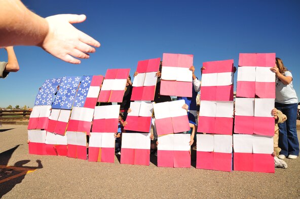Spectators clap and cheer as fifth grade students hold up their mosaic display simulating the American flag during a Veterans Day parade at Sunrise Elementary School in Aurora, Colo., Oct. 17, 2008. The school is hosting its fifth annual parade to honor former and current members of the U.S. armed forces. Current members of the 140th Wing, Colorado Air National Guard, from Buckley Air Force Base, Colo., lined a sidewalk to show support for the students, and also judged the patriotic event. (Official U.S. Air Force photo by Tech. Sgt. Cheresa D. Theiral) (Released) 