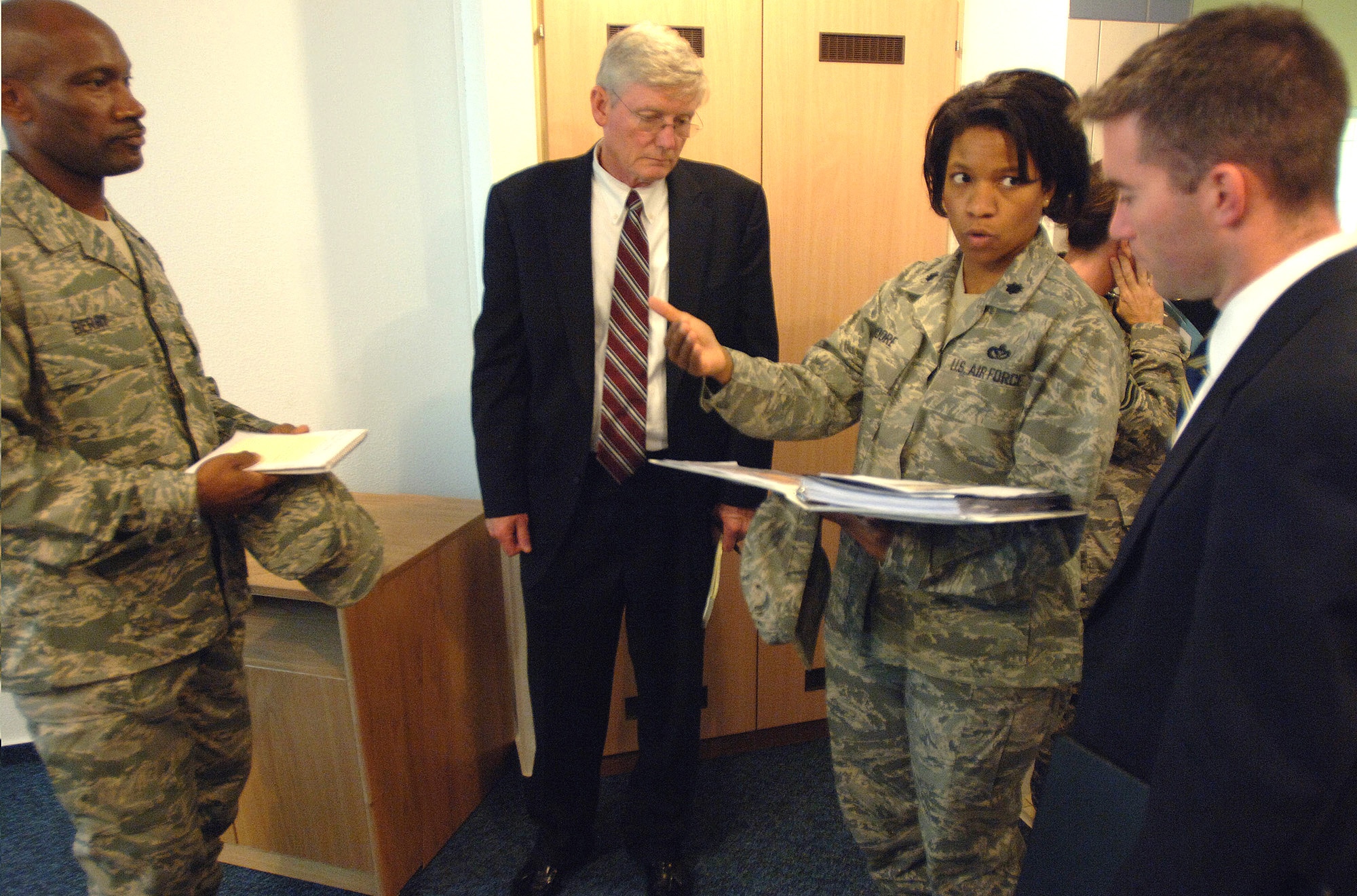 Lt. Col. Bobbie Moore describes how maintenance repairs impact Airmen living in unaccompanied dorms with Keith Baker (center) and Adam Johnson while Master Sgt. Bradford Berry looks on Oct. 16 in Kaiserslautern, Germany. The discussion was part of a Department of Defense-wide investigation that canvassed nearly 60 installations worldwide. Colonel Moore is the 435th Civil Engineer Squadron commander. Mr. Baker and Mr. Johnson are House Appropriations Committee staff delegates. Sergeant Berry is the unaccompanied housing superintendent. (U.S. Air Force photo/Master Sgt. Scott Wagers) 
