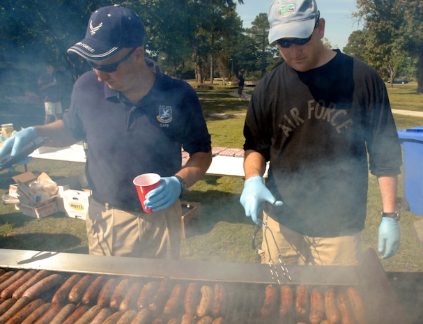 Master Sgt.  Ron Whidden, left and Master Sgt. Jeff Wagner, right, cook bratwursts for the Oktoberfest held on Charleston AFB Oct. 17. The Charleston AFB Top 3 provided food, drinks and entertainment for junior?enlisted Airmen during the annual event.  Sergeants Whidden and Wagner are both from the 437th Security Forces Squadron. (U.S. Air Force photo/Staff Sgt. Jennifer Arredondo)