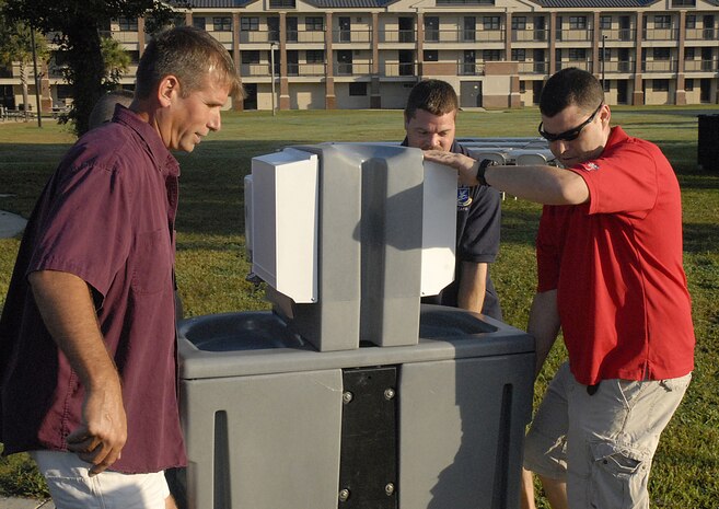 From left to right, Senior Master Sgt. Damian Fox and Master Sgts. Donald Hart and Justin Strain position a hand-washing station for Oktoberfest on Charleston AFB Oct. 17. The Charleston AFB Top 3 provided food, drinks and entertainment for junior-enlisted Airmen during the annual event. Sergeant Fox is with the 437th Operations Group, Sergeant Hart is with the 437th Secirity Forces Squadron and Sergeant Strain is with the 14th Airlift Squadron. (U.S. Air Force photo/Master Sgt. Paul Kilgallon)