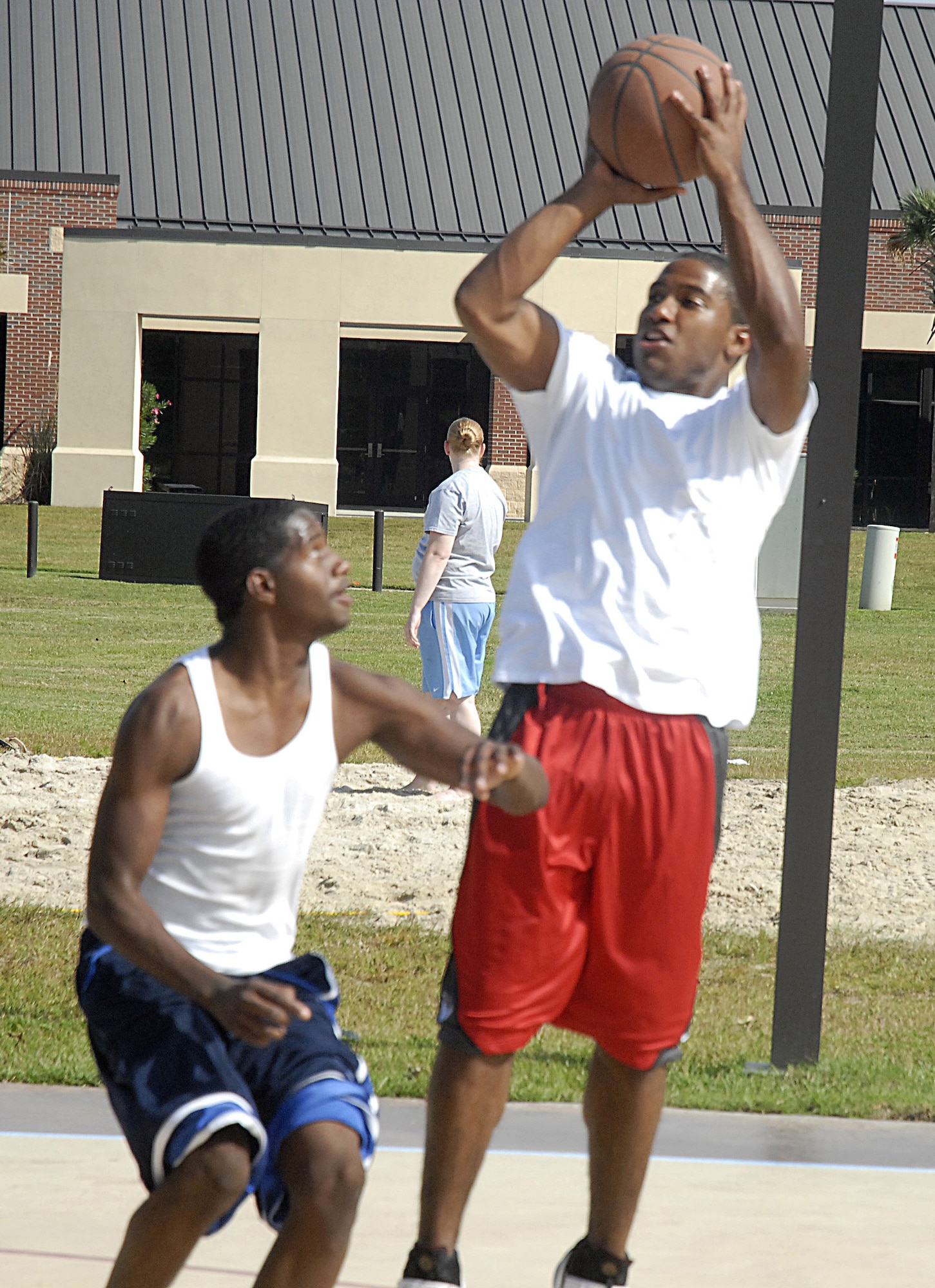 Senior Airman Averion Williamson shoots the basketball over Airman 1st Class Todd Tolbert during Oktoberfest on Charleston AFB Oct. 17. The Charleston AFB Top 3 provided food, drinks and entertainment for junior-enlisted Airmen during the annual event. Airman Williamson is with the 437th Force Support Squadron and Airman Tolbert is with the 437th Logistics Readiness Squadron. (U.S. Air Force photo/Master Sgt. Paul Kilgallon)  