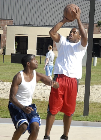 Senior Airman Averion Williamson shoots the basketball over Airman 1st Class Todd Tolbert during Oktoberfest on Charleston AFB Oct. 17. The Charleston AFB Top 3 provided food, drinks and entertainment for junior-enlisted Airmen during the annual event. Airman Williamson is with the 437th Force Support Squadron and Airman Tolbert is with the 437th Logistics Readiness Squadron. (U.S. Air Force photo/Master Sgt. Paul Kilgallon)  